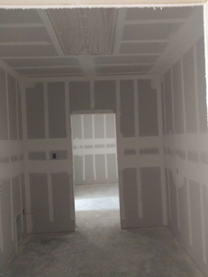 An empty room with drywall on the walls and ceiling.