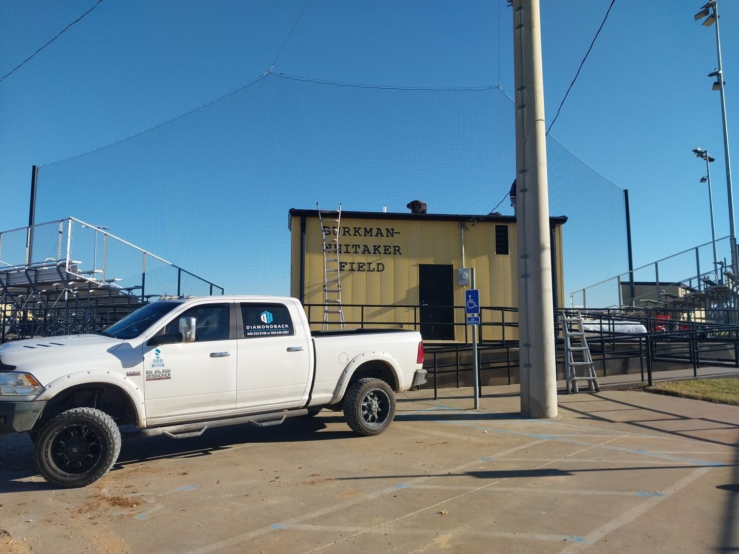A white truck is parked in front of a building that says texas
