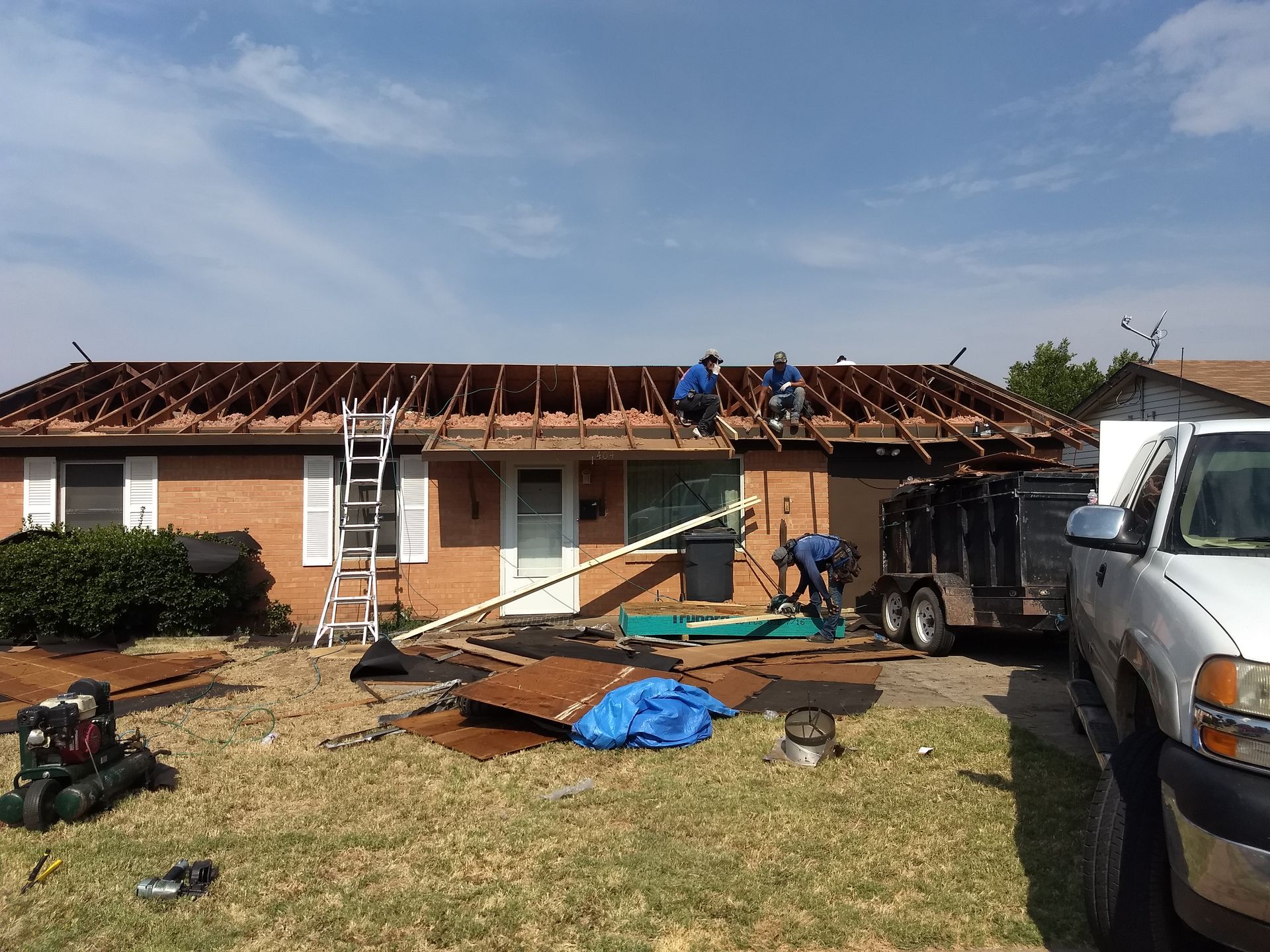 A group of men are working on the roof of a house.