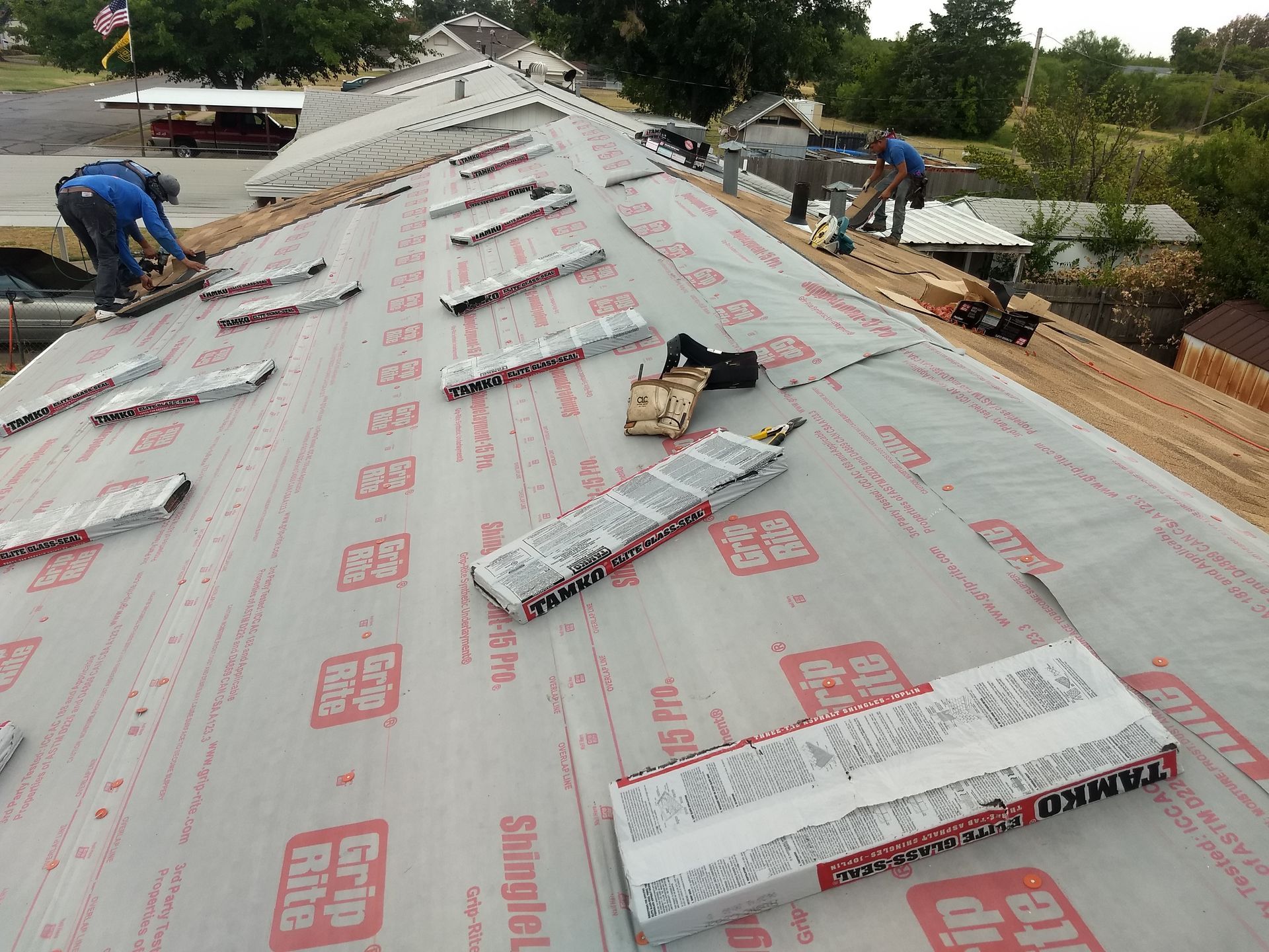 A man is working on a roof with shingles on it
