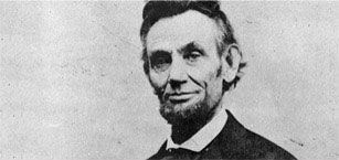 Abraham lincoln is smiling in a black and white photo.