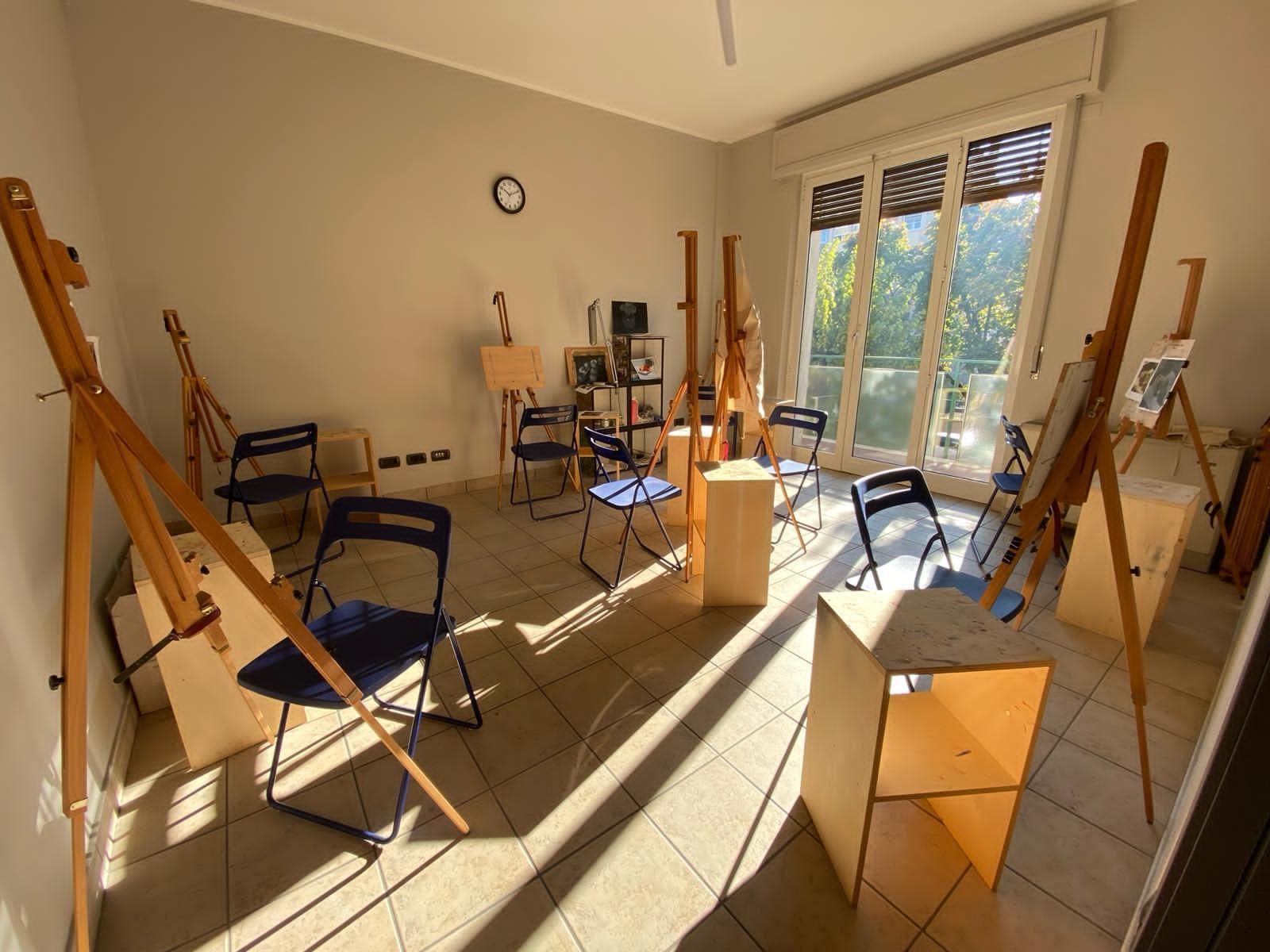 Una stanza con molte sedie e cavalletti.