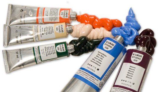 Su un tavolo c'è un mucchio di tubetti di vernice