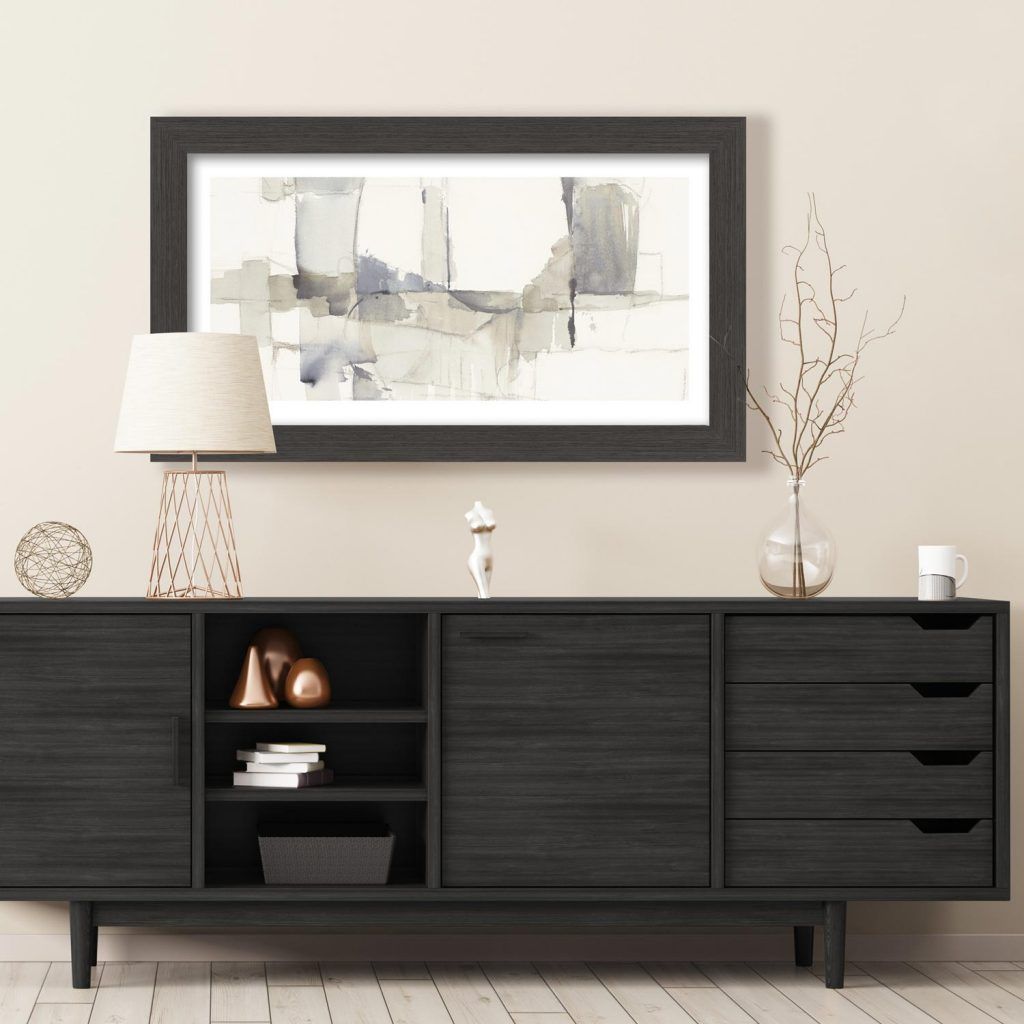 Un cassettone nero con un quadro appeso alla parete sopra