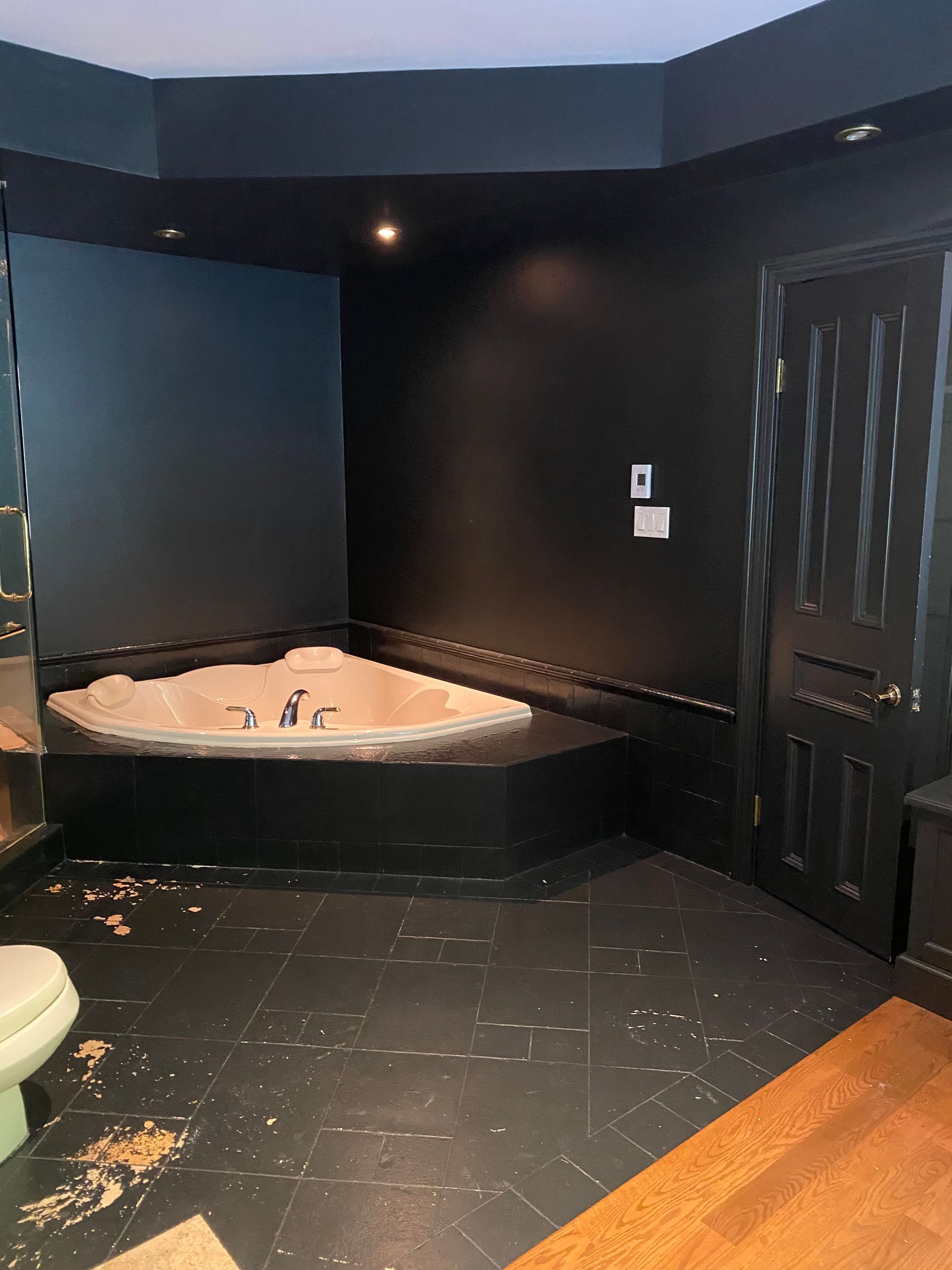 Une salle de bain avec baignoire jacuzzi et murs noirs