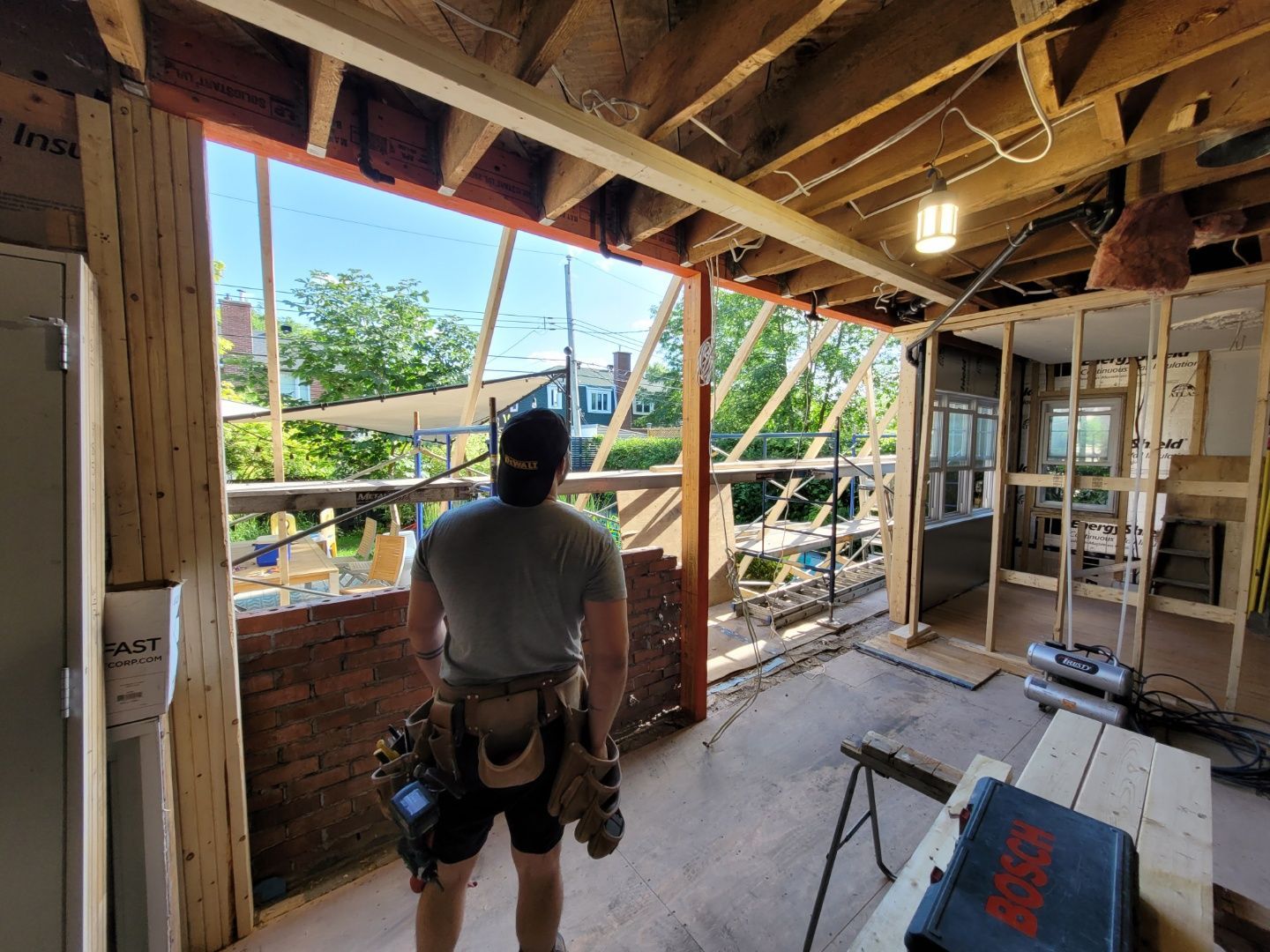 Un homme se tient debout dans une pièce en construction et regarde par la fenêtre.