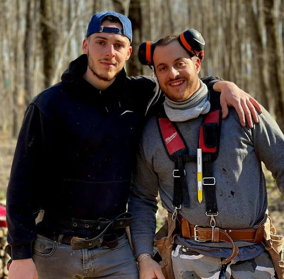 Deux hommes posant pour une photo, l'un d'eux portant des écouteurs