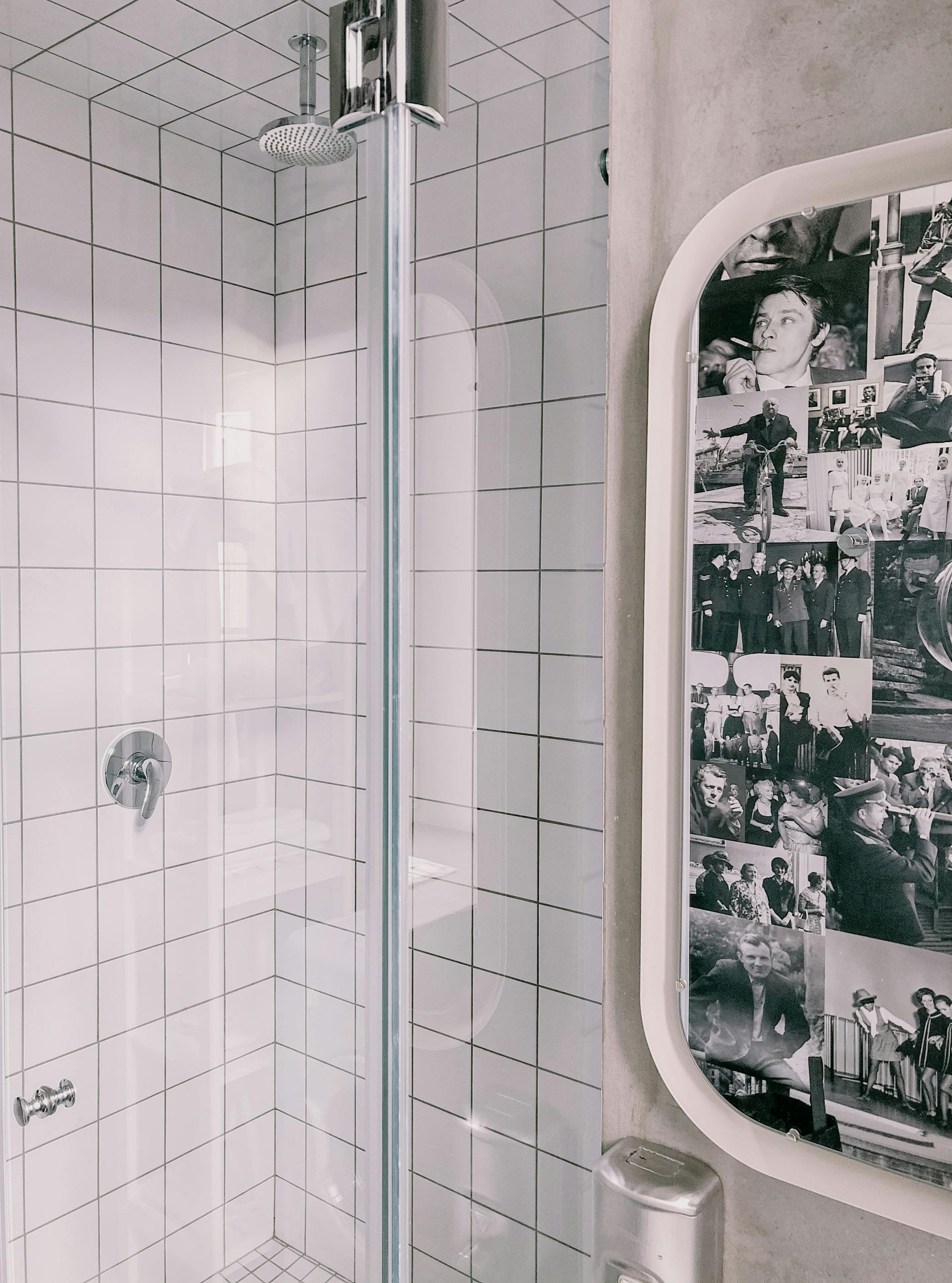 Une salle de bain avec du carrelage blanc et un tableau au mur