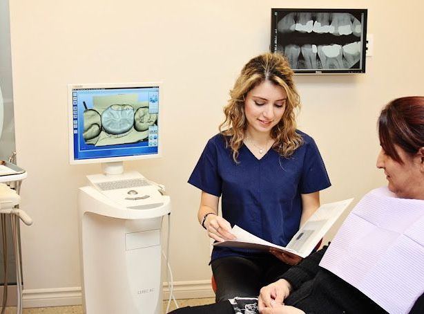 A female dentist is talking to a patient in a dental office.