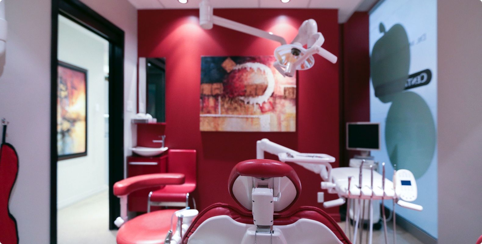 Un cabinet dentaire avec des murs rouges et un fauteuil dentaire rouge