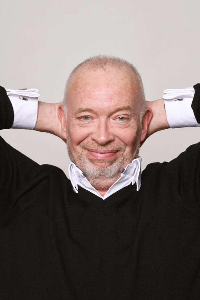 Frans Mulder, cabaretier en zanger, met zijn handen achter zijn hoofd en lacht. Nederlied, Pride Show in Theater Het Zonnehuis in Amsterdam-Noord