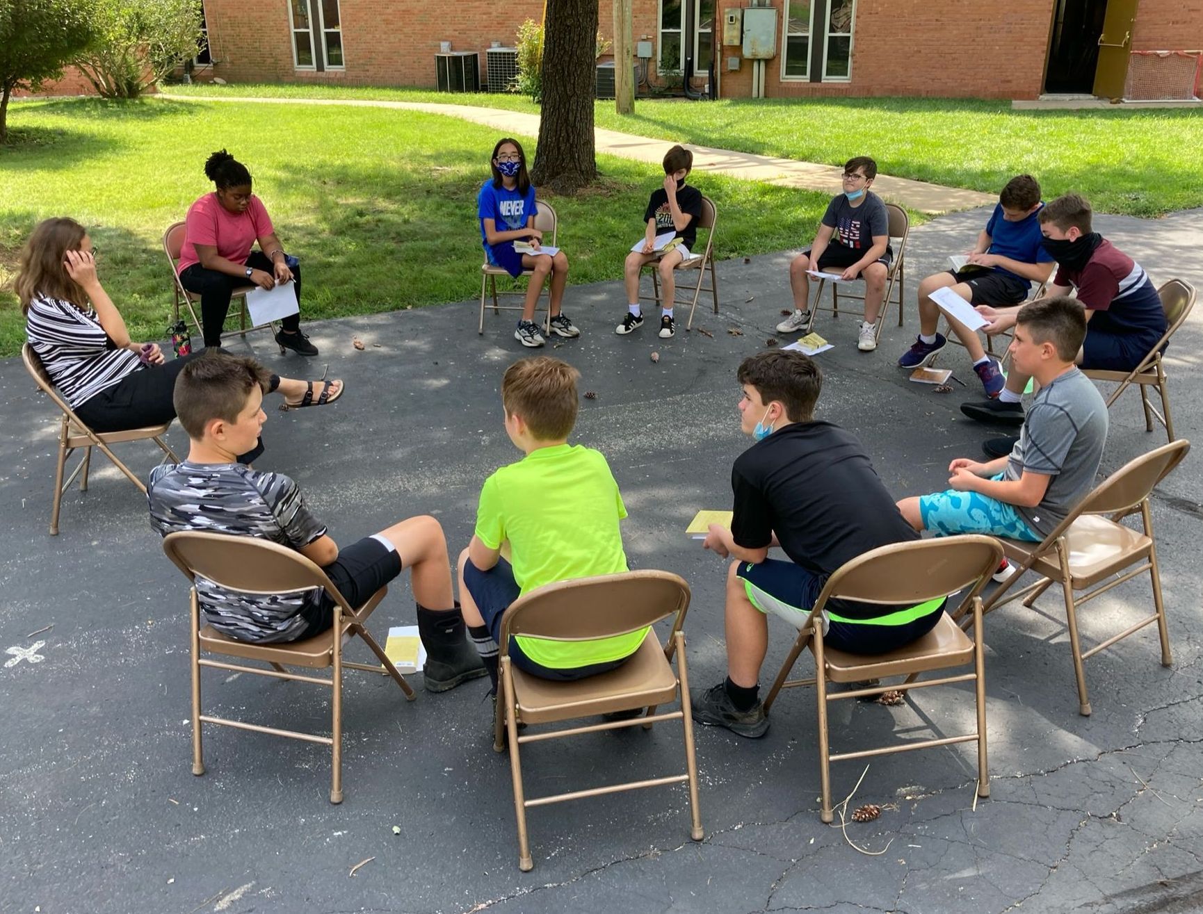 Middle School students participating in a seminar outside in a circle. 