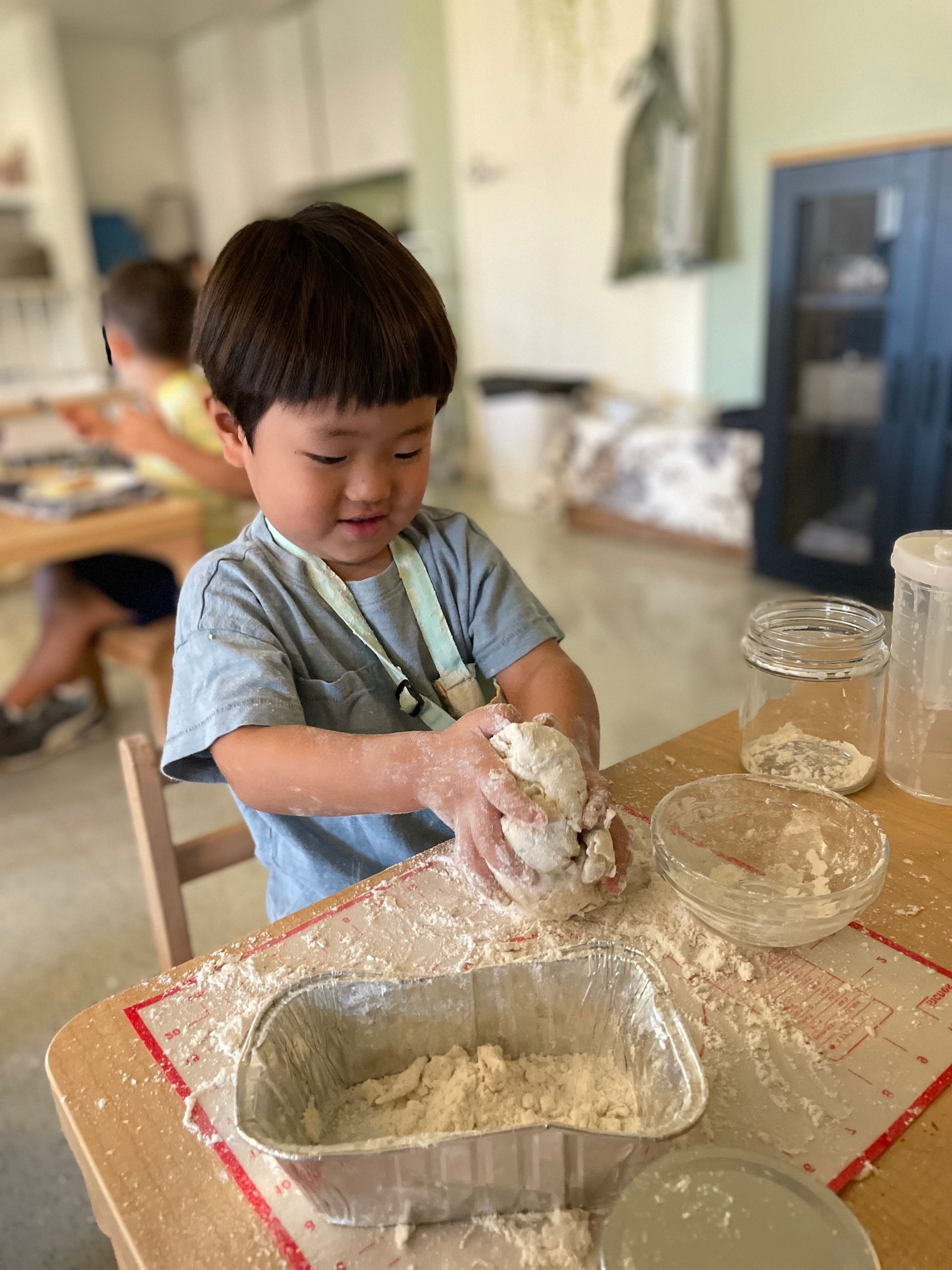A child rolling their own dough for breadmaking.