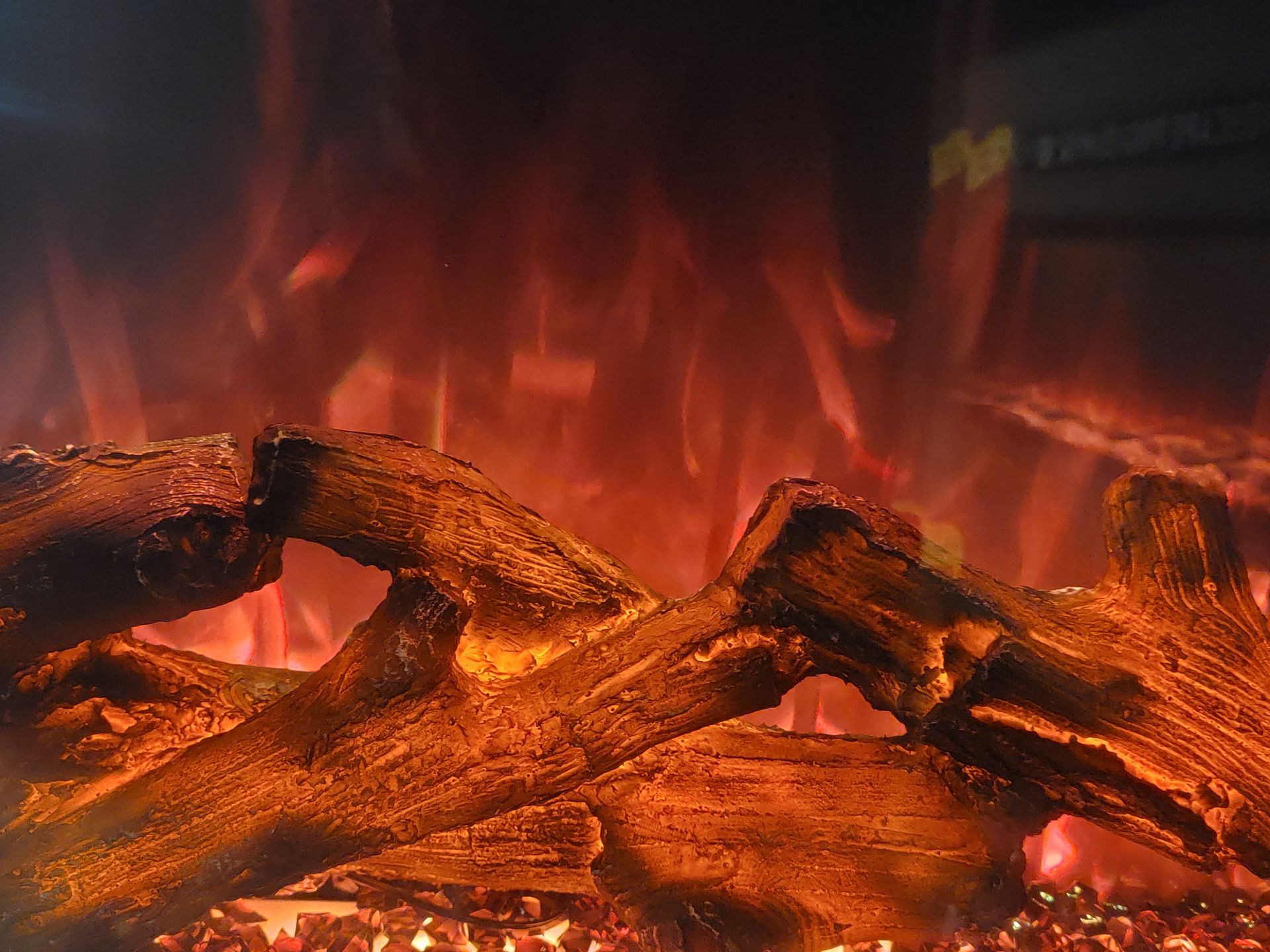Logs in a fireplace with orange flames.