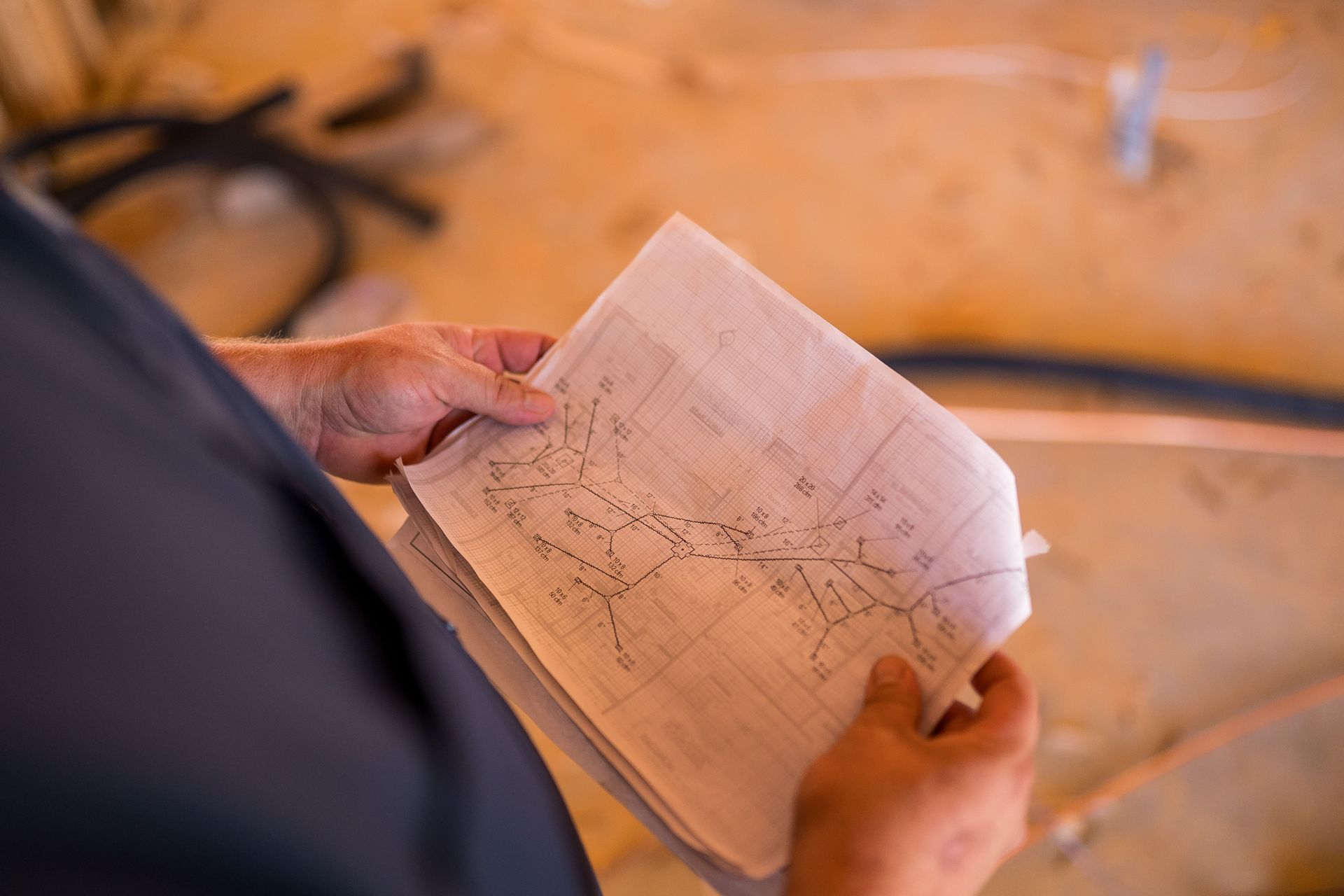 Person holding a blueprint, likely reviewing plans during construction.