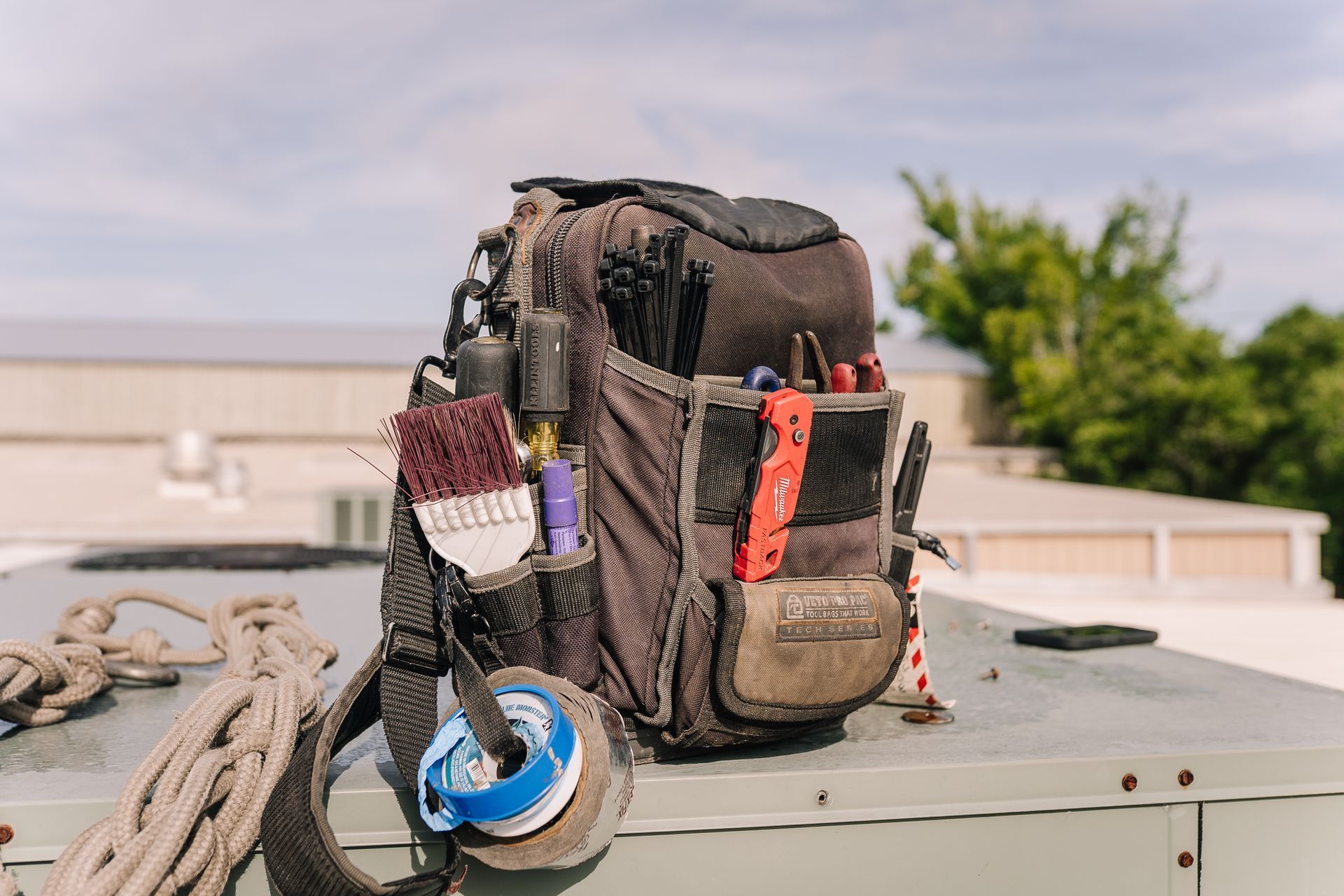 Tool bag with tools on a rooftop.