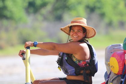 A river guide rowing a boat.