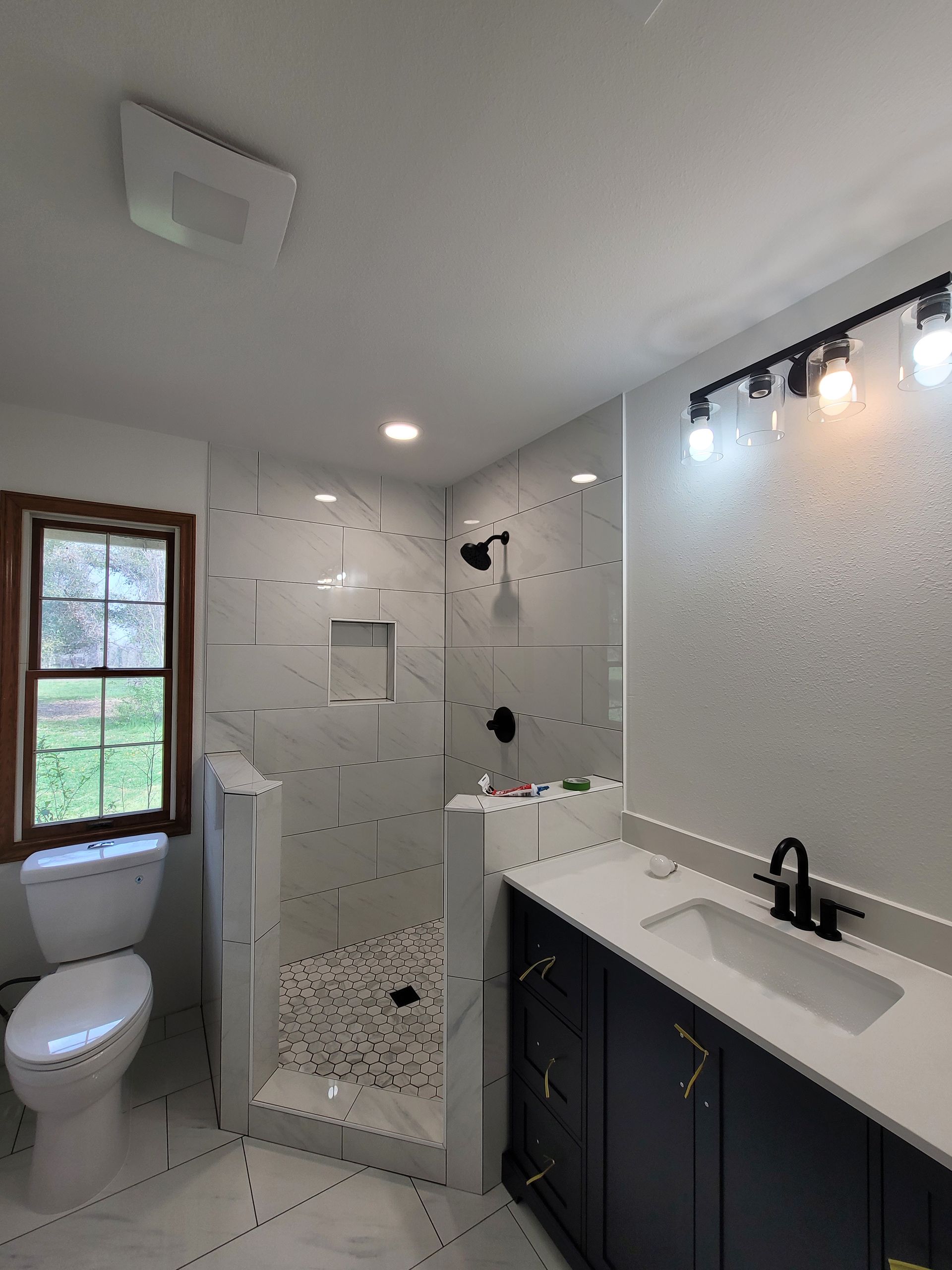 A bathroom with a toilet a sink and a shower