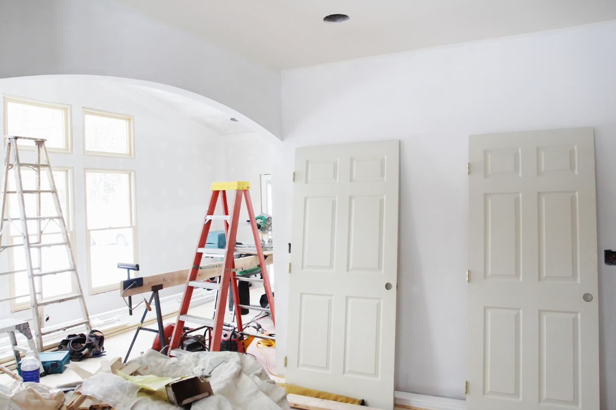 A room is being remodeled with white doors and a ladder.