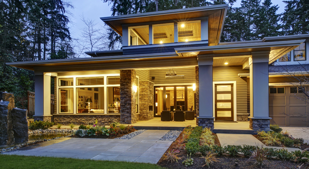 A custom home with a lot of windows is lit up at night.