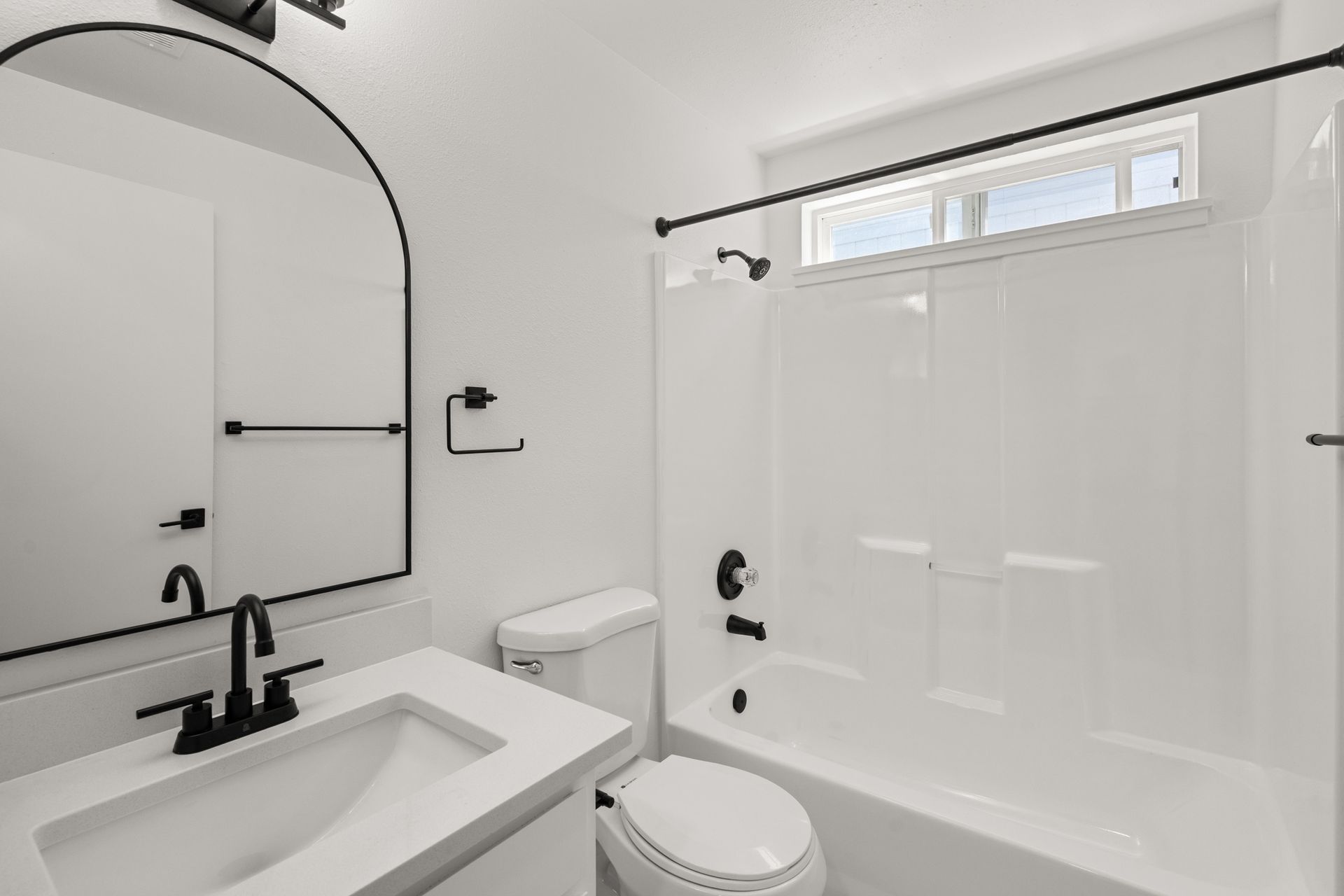 A bathroom with a toilet , sink , and bathtub.