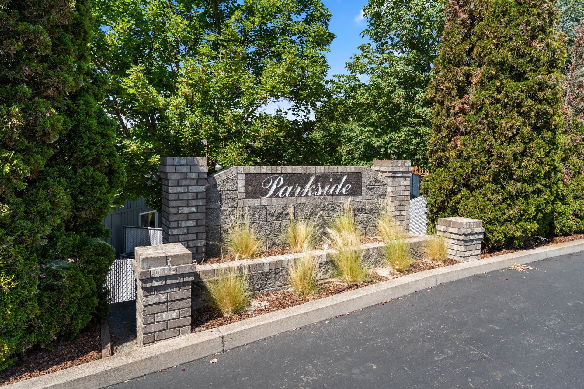 A sign for parkside is surrounded by trees and bushes