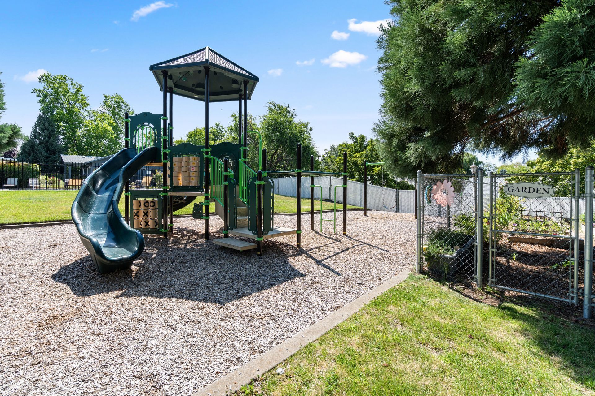 A playground with a slide and a tower in a park.