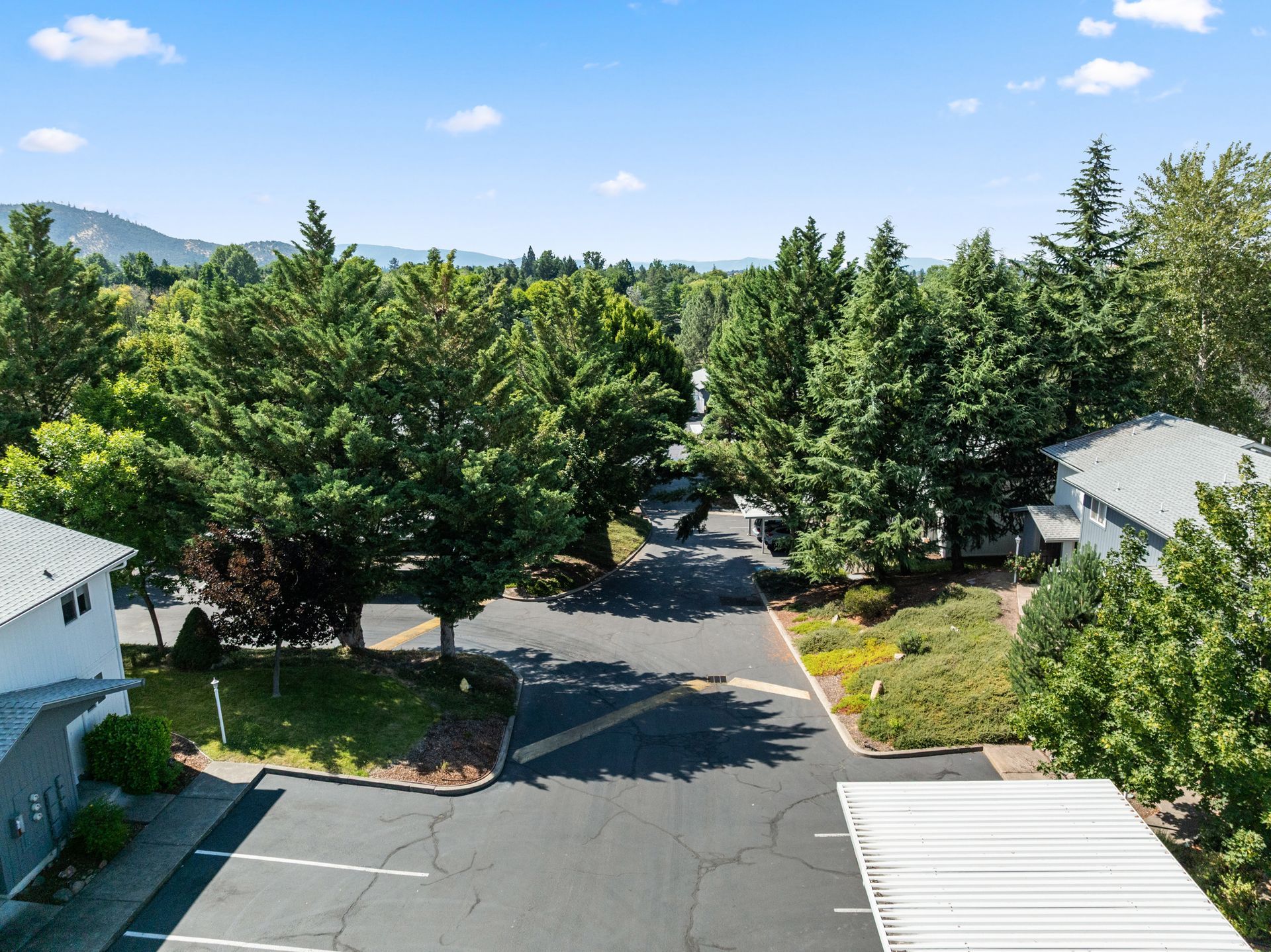 An aerial view of a parking lot surrounded by trees and buildings.