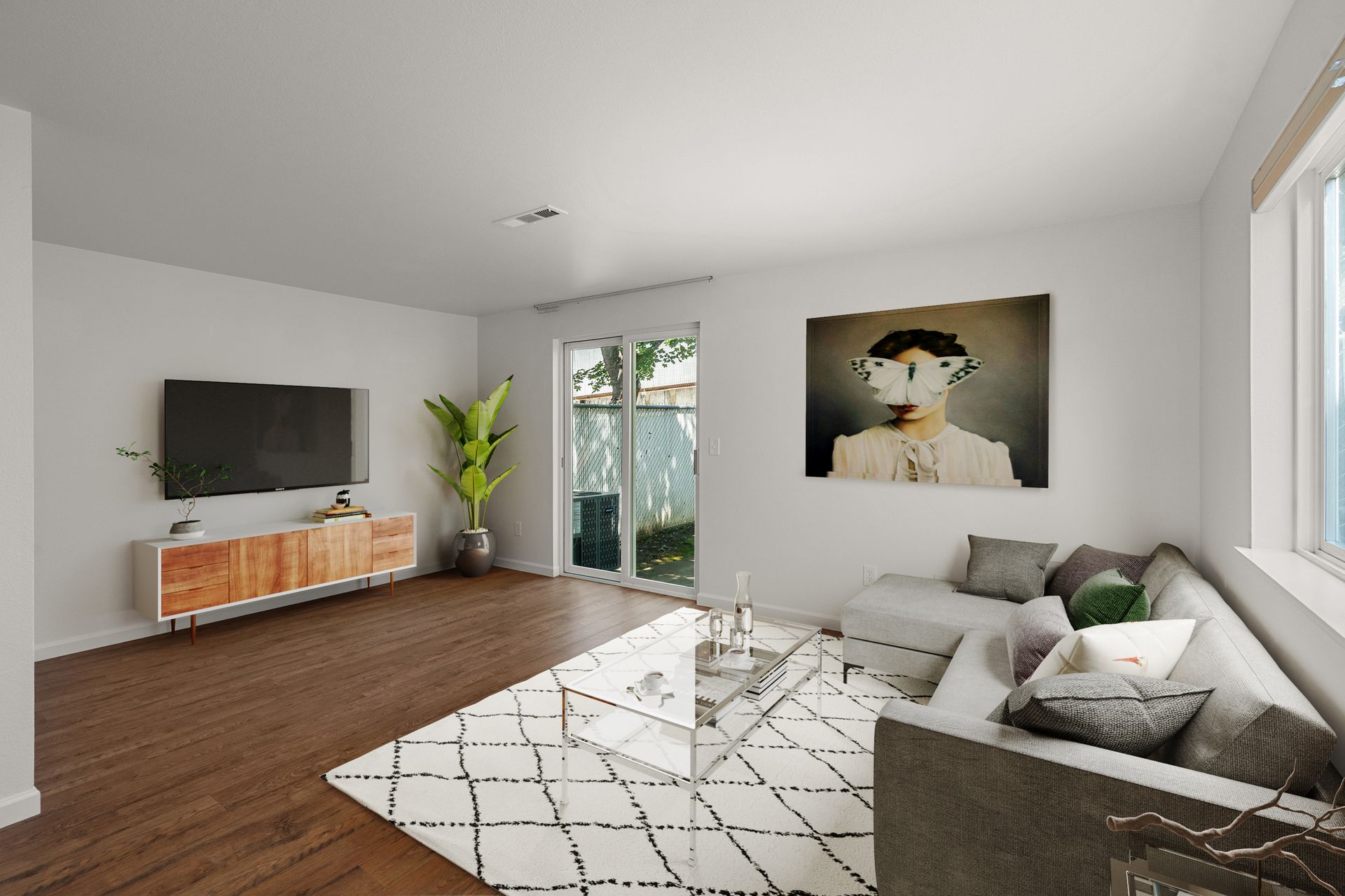 A living room with a couch , television , and a painting on the wall.