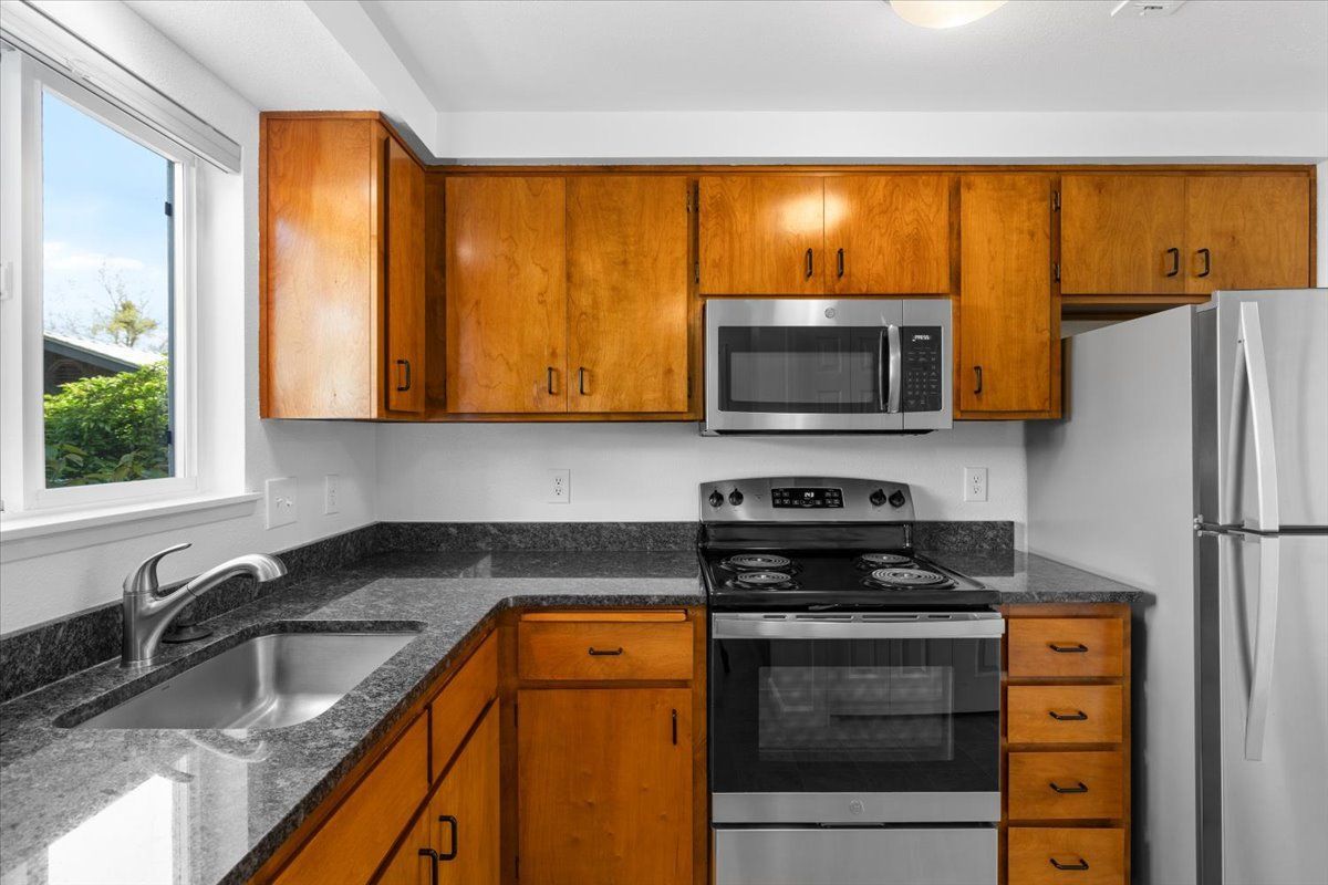 A kitchen with stainless steel appliances and wooden cabinets