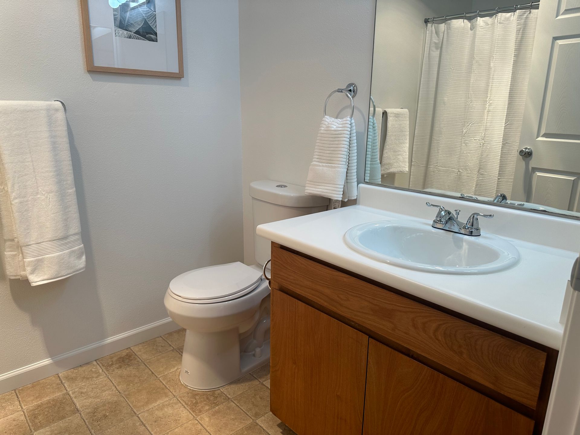 A bathroom with a toilet , sink and mirror