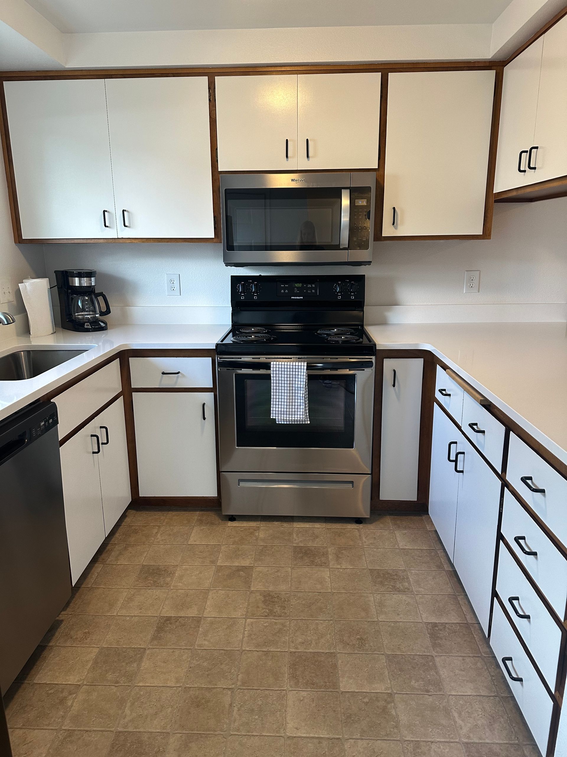 A kitchen with stainless steel appliances and white cabinets