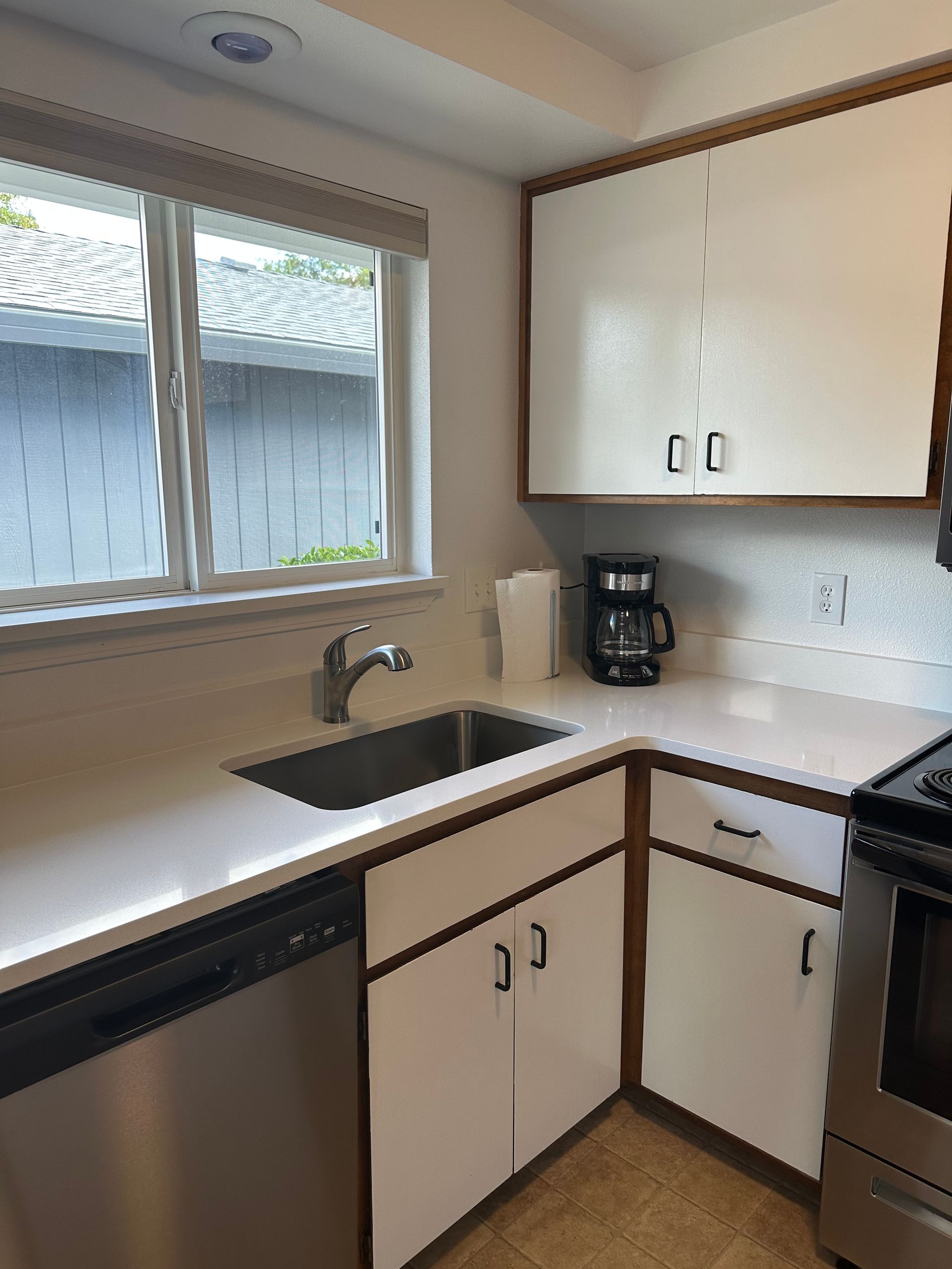 A kitchen with white cabinets and stainless steel appliances