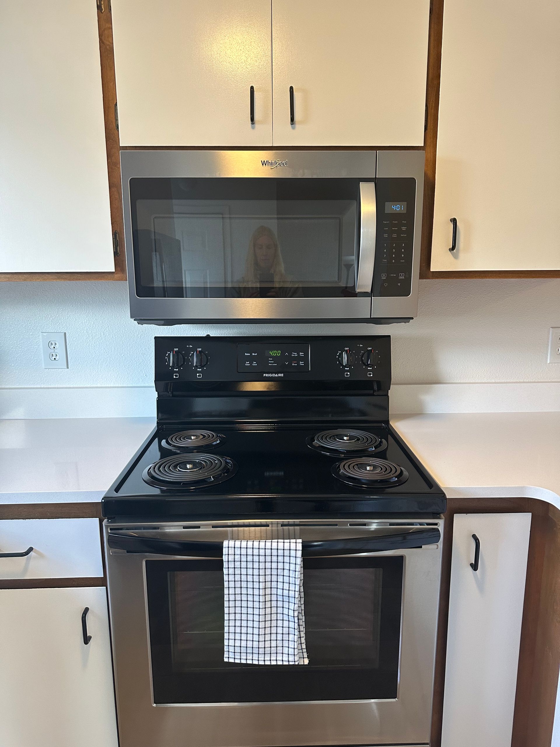 A kitchen with a stove top oven and a microwave