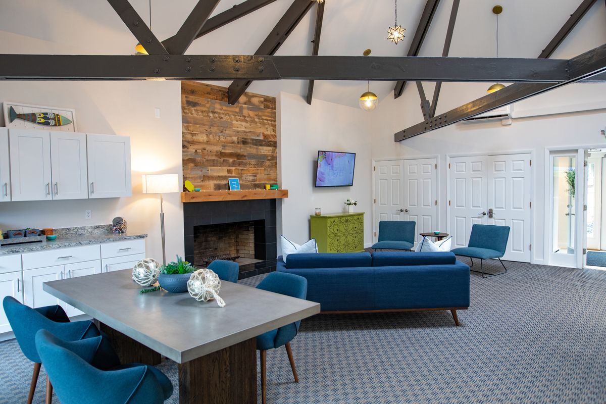 Interior living area with blue furniture, fireplace, and exposed beams.