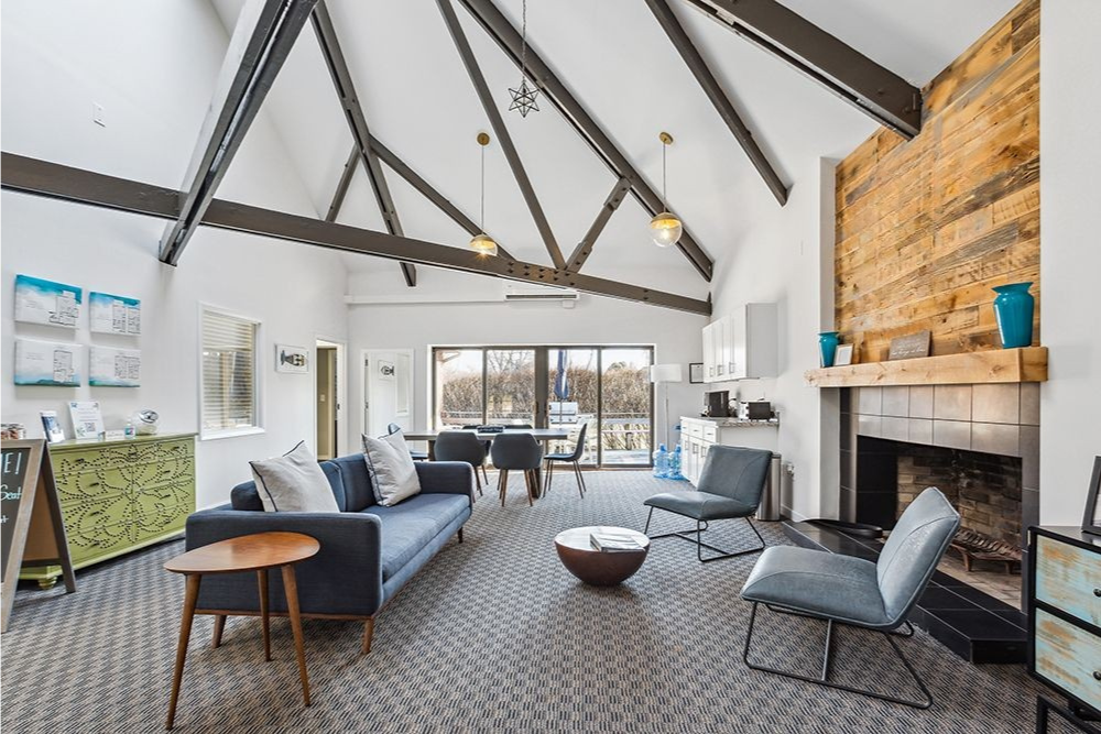 Living room with vaulted ceiling, fireplace, and modern furniture.