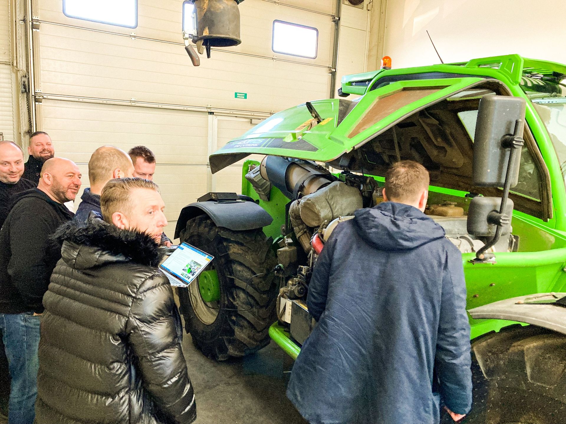 A Group of Men Are Standing Around a Green Tractor With Its Hood Open — MPE Adventure Quads & Bikes In Port Stephens, NSW