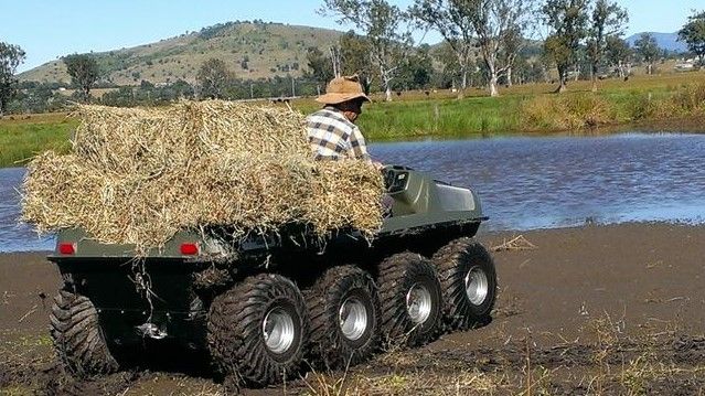 A Man is Driving an ATV With Hay on the Back — MPE Adventure Quads & Bikes In Singleton, NSW