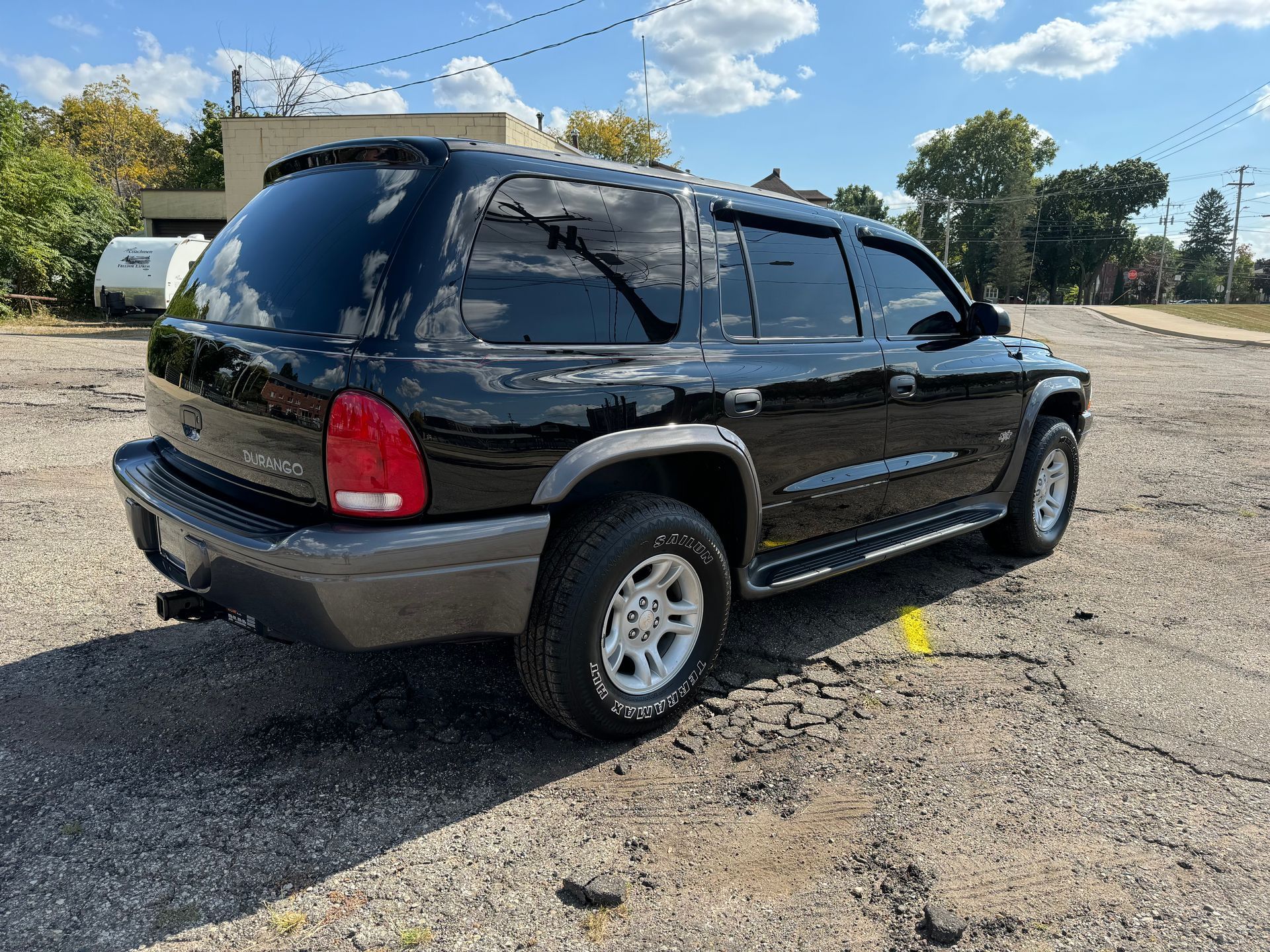 A black dodge durango is parked in a parking lot.