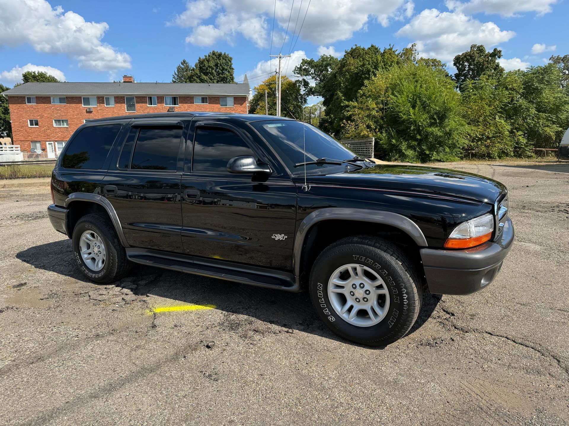 A black dodge durango is parked in a parking lot.