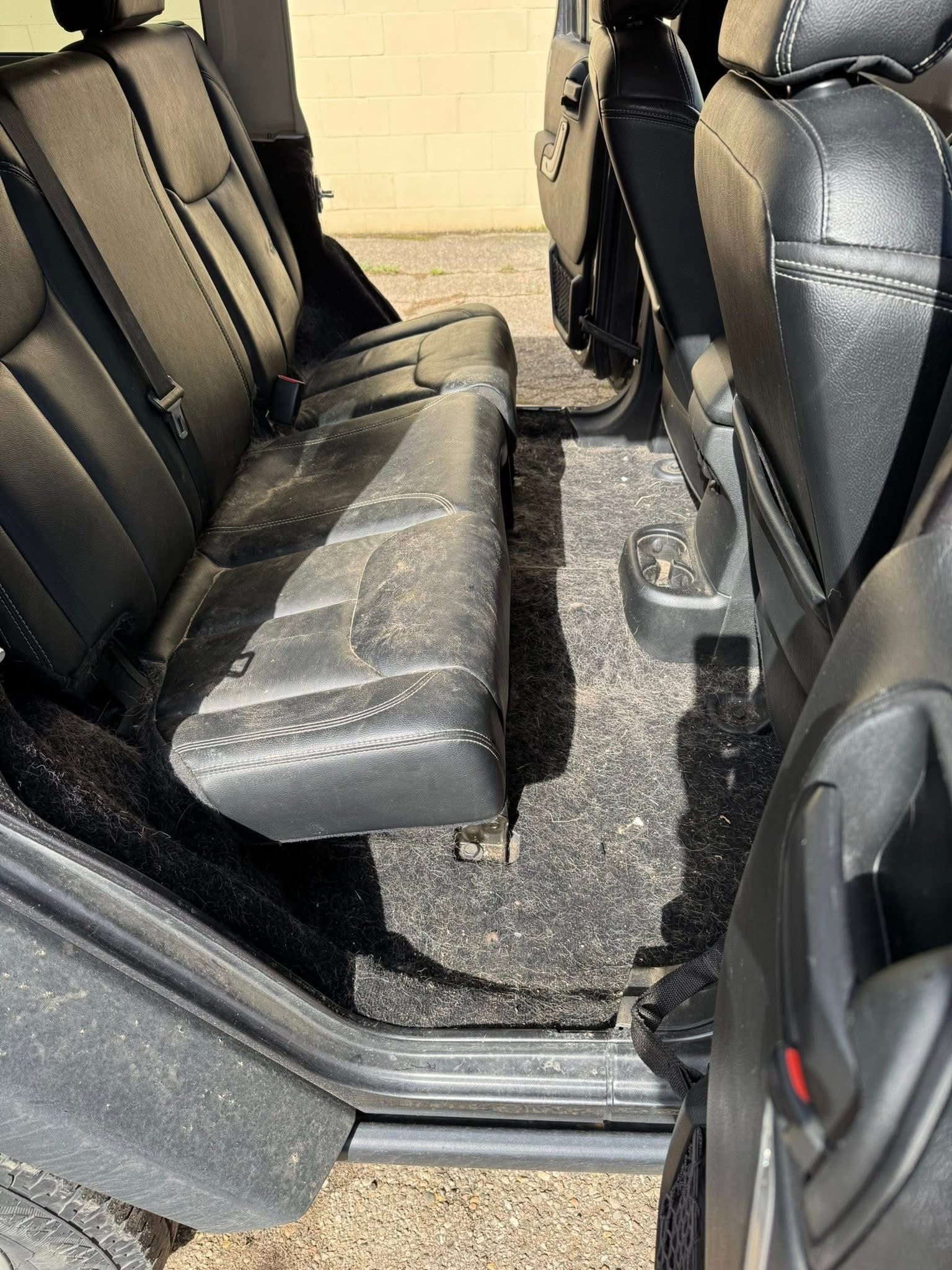 The back seat of a jeep wrangler with the door open.