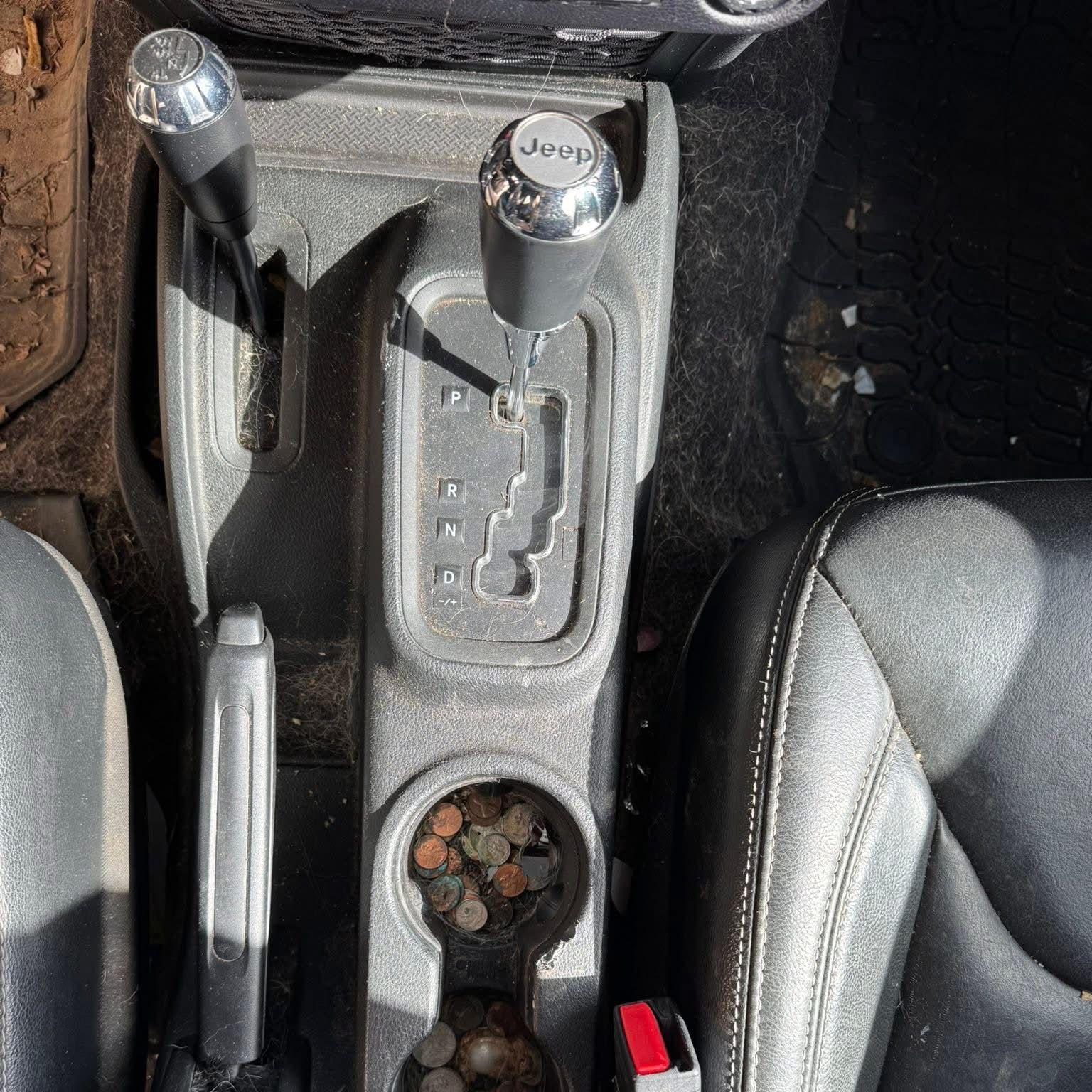 The back seat of a jeep wrangler with the door open.