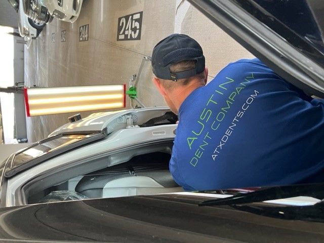 An Austin Dent Company expert in paintless dent repair inspects his work.