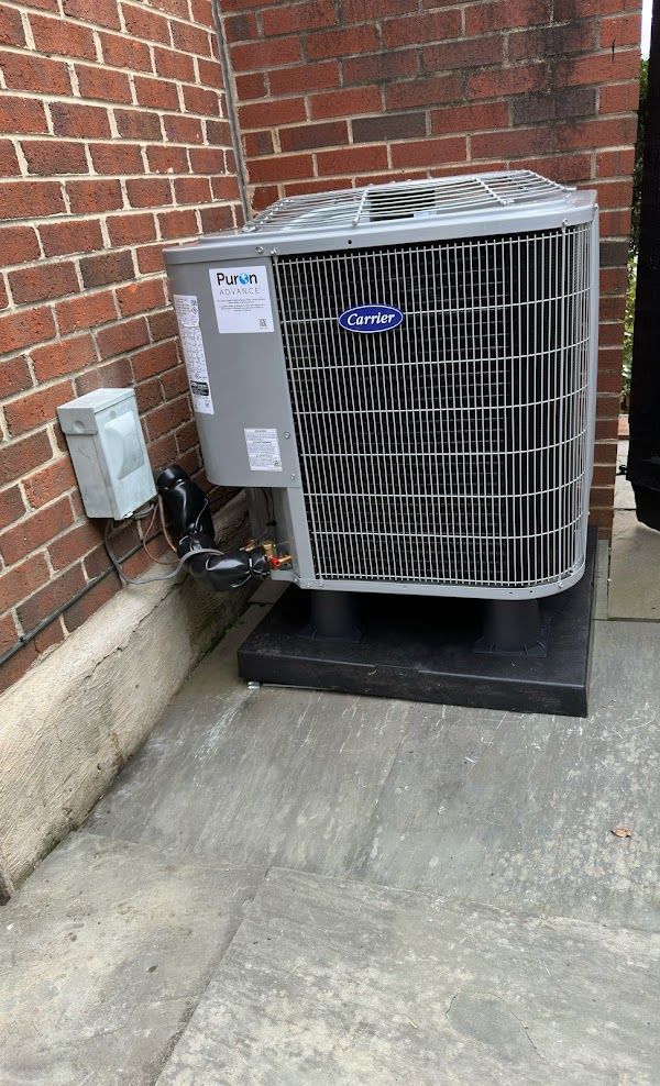 Carrier AC installation beside home exterior wall by Alex HVAC Service LLC