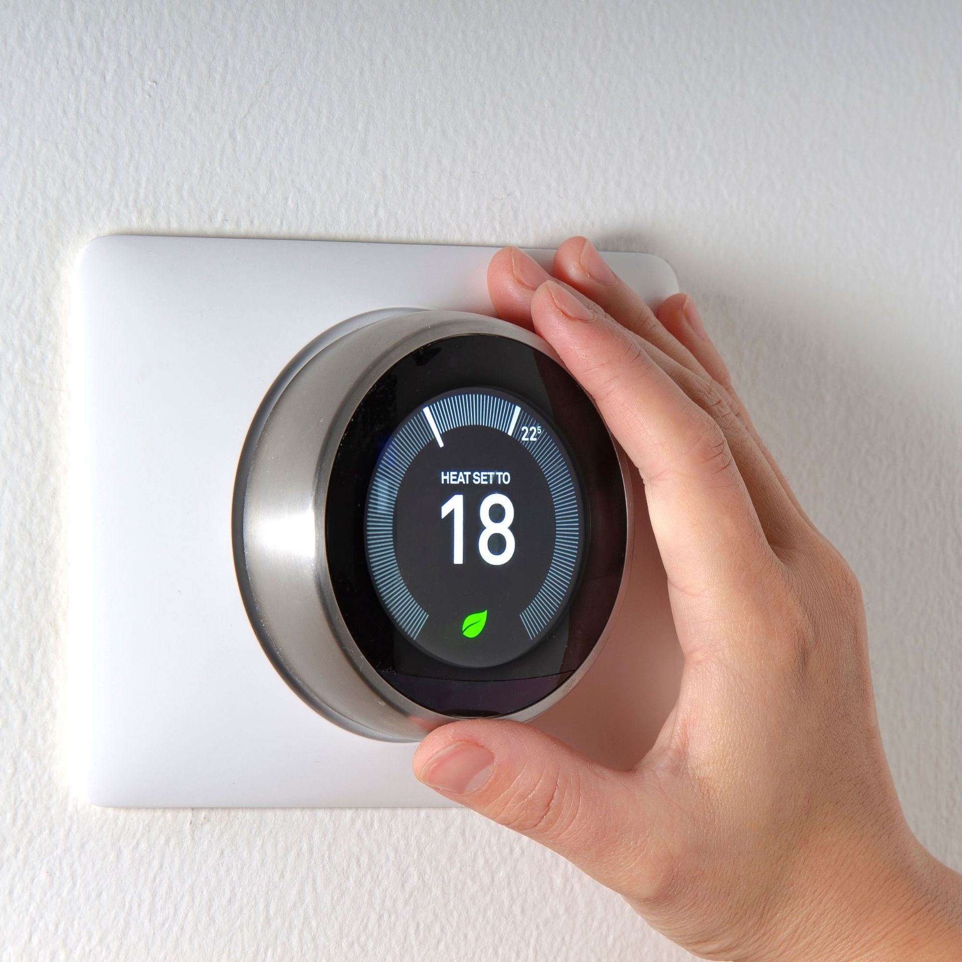 Alex HVAC Service LLC | A person is adjusting a thermostat with the number 18 on it