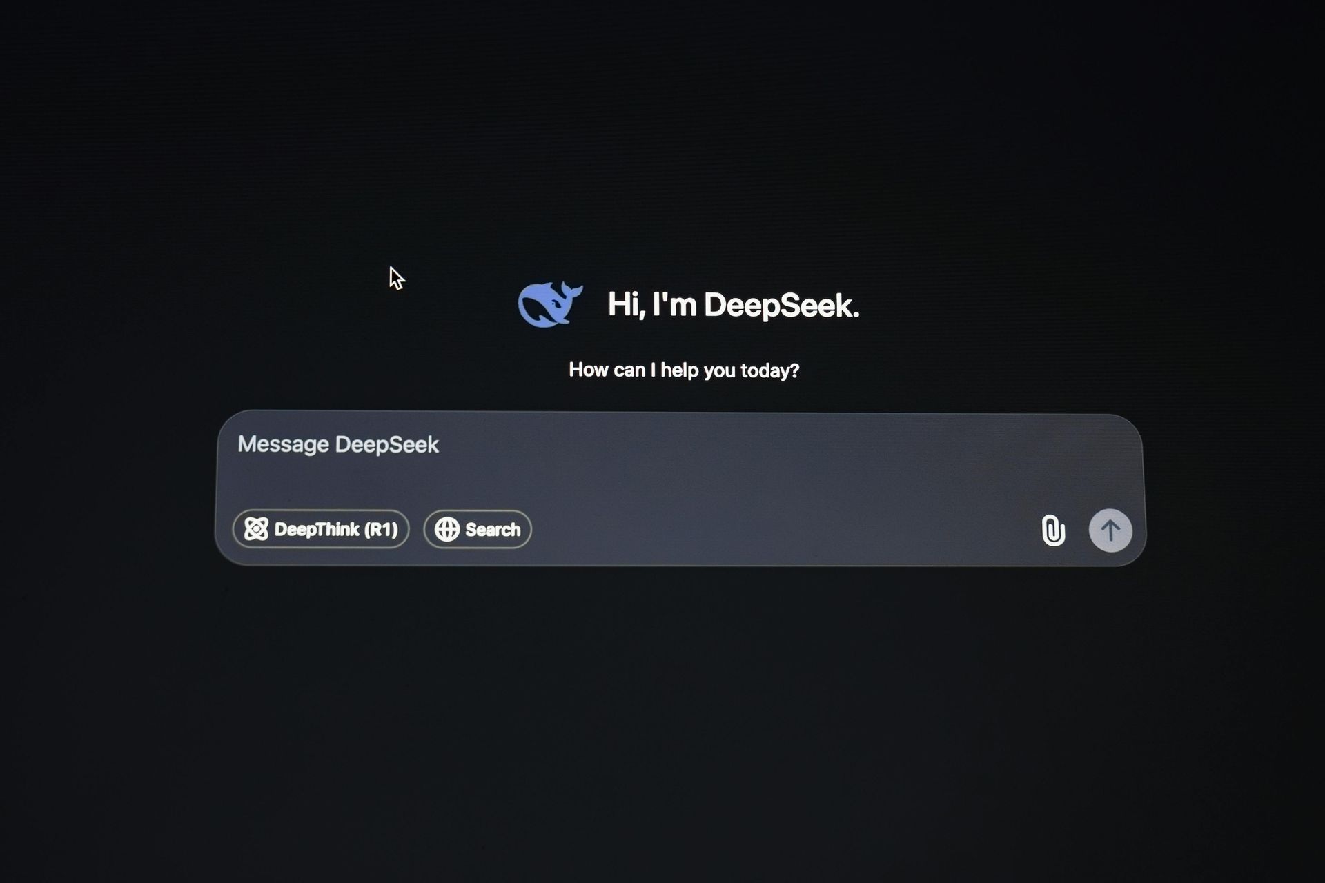DeepSeek AI chatbot interface, dark theme. A message bubble displays “Hi. I’m DeepSeek. How can I help you today?” with input field.