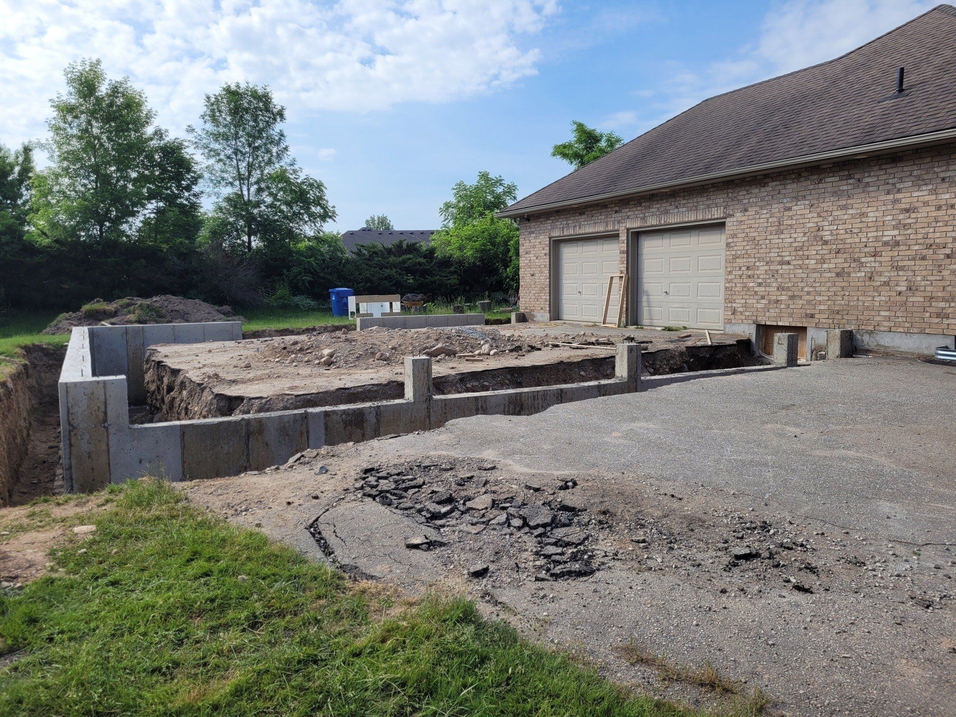 A brick building with two garage doors is being built