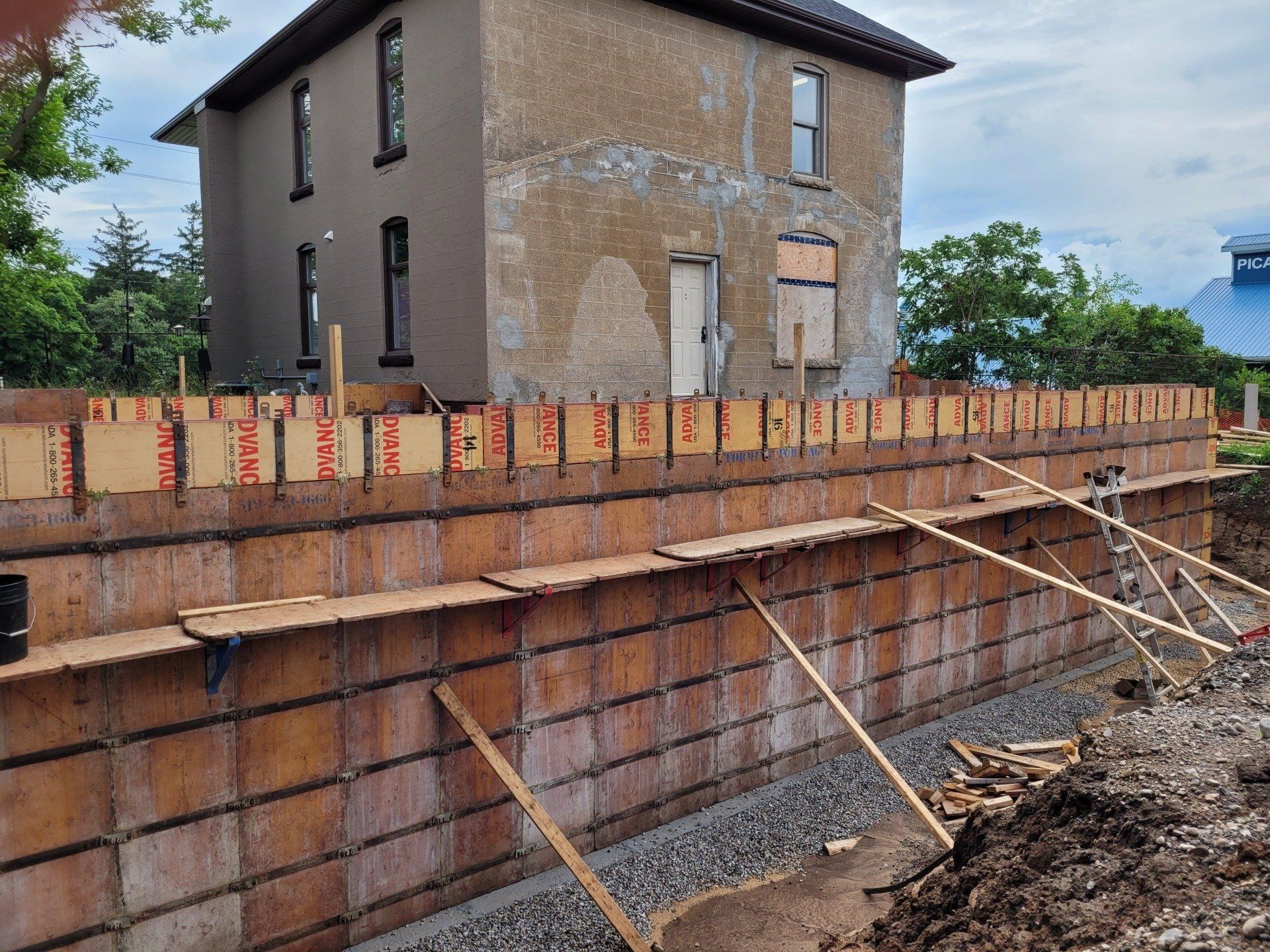 A brick wall is being built in front of a house