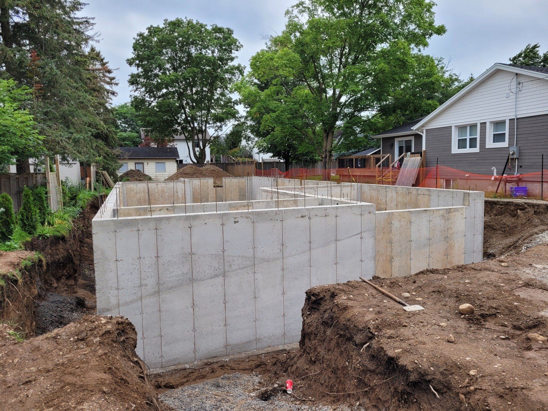 A large concrete wall is being built in front of a house.