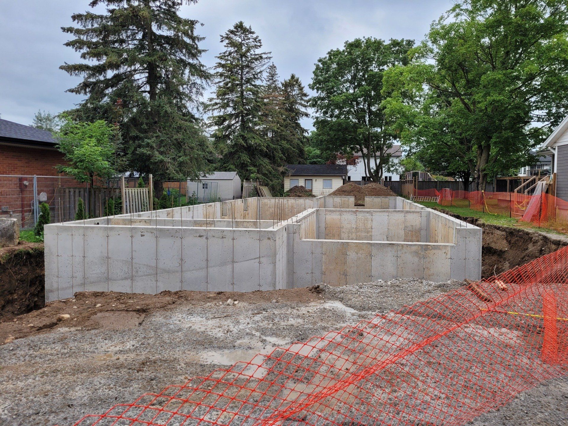 A large concrete foundation is being built in the middle of a dirt field.